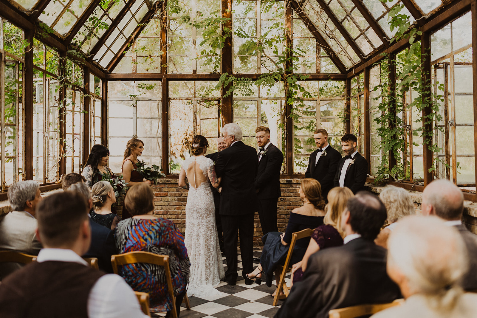 couple exchanges vows at Sekrit Theater greenhouse wedding