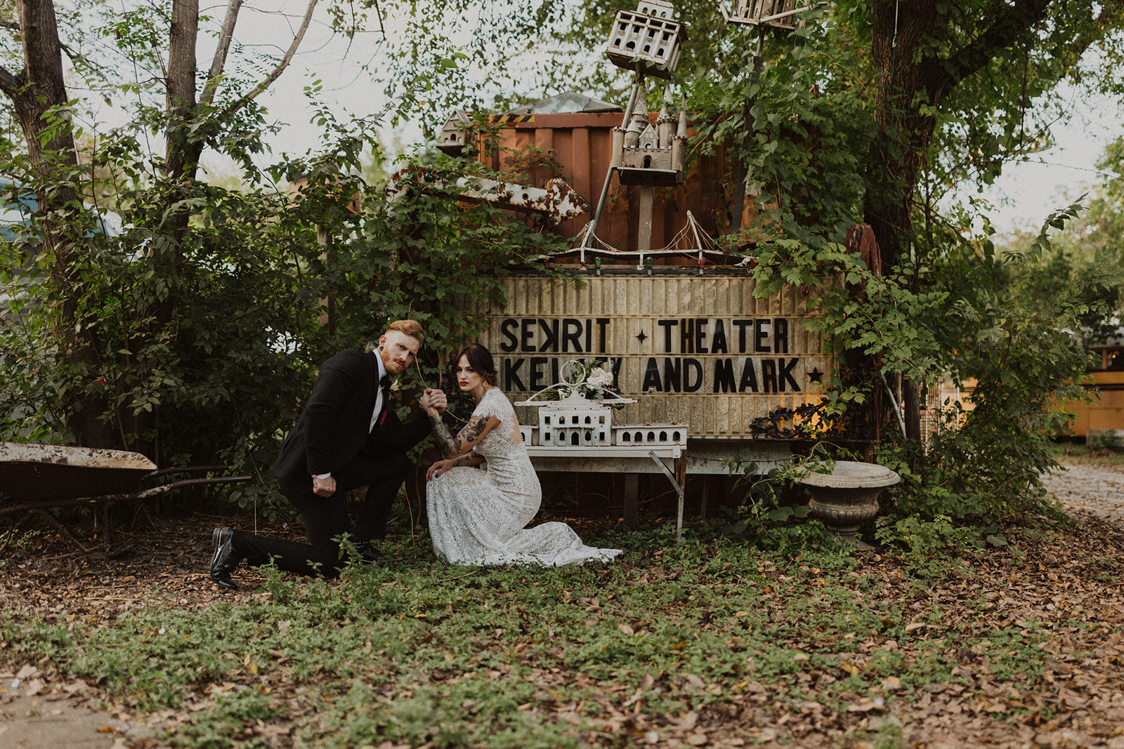 couple stands by wedding sign at outdoor wedding