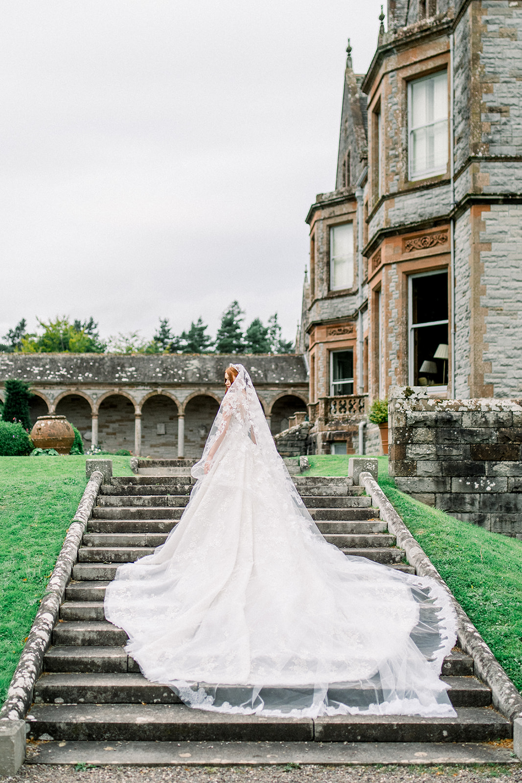 Bride caressing her delicate lace wedding gown by Rami Al Ali, capturing the essence of Castle Leslie's elegance