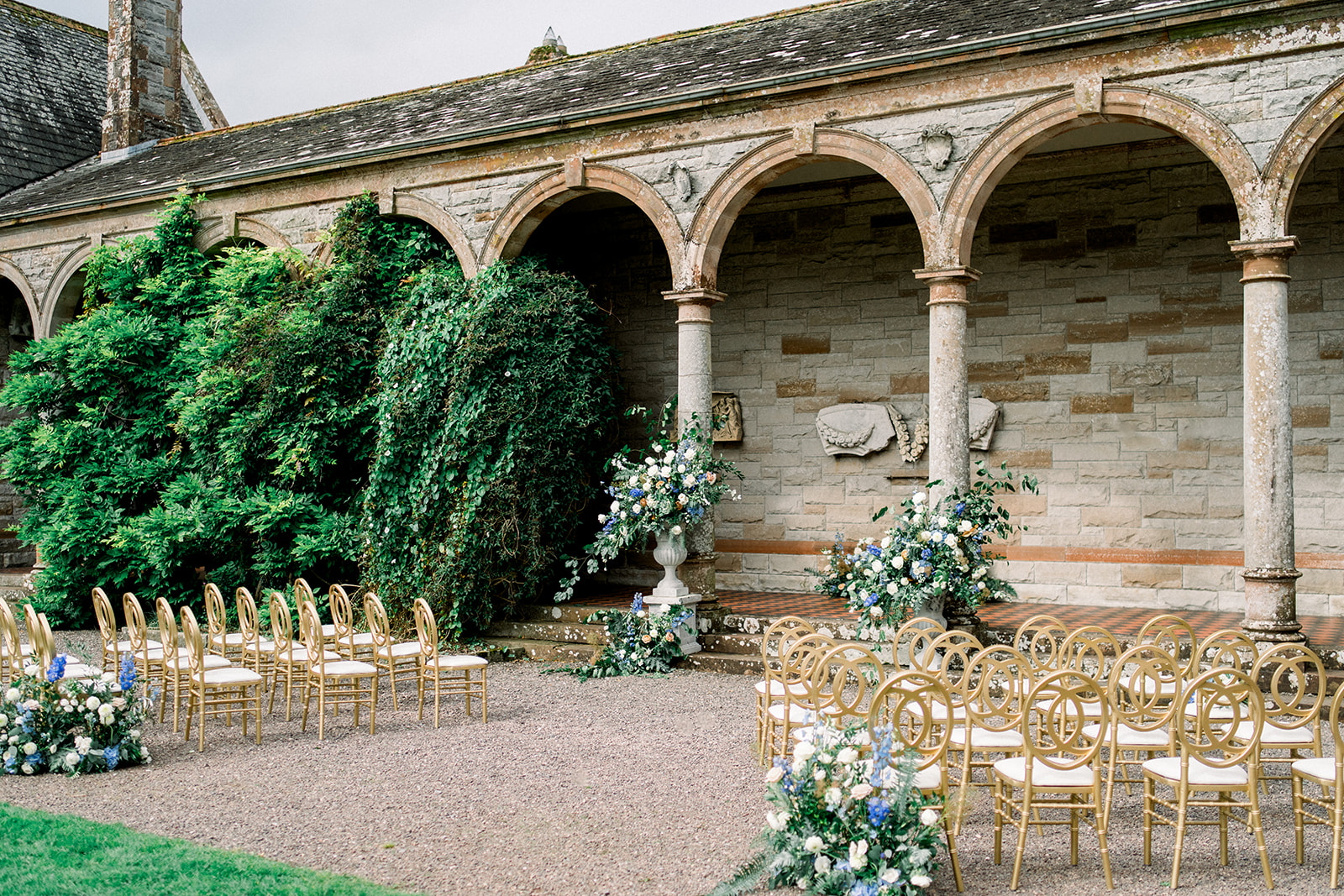 Destination wedding ceremony setup in Ireland, showcasing Castle Leslie's courtyard with elegant golden chairs and flora