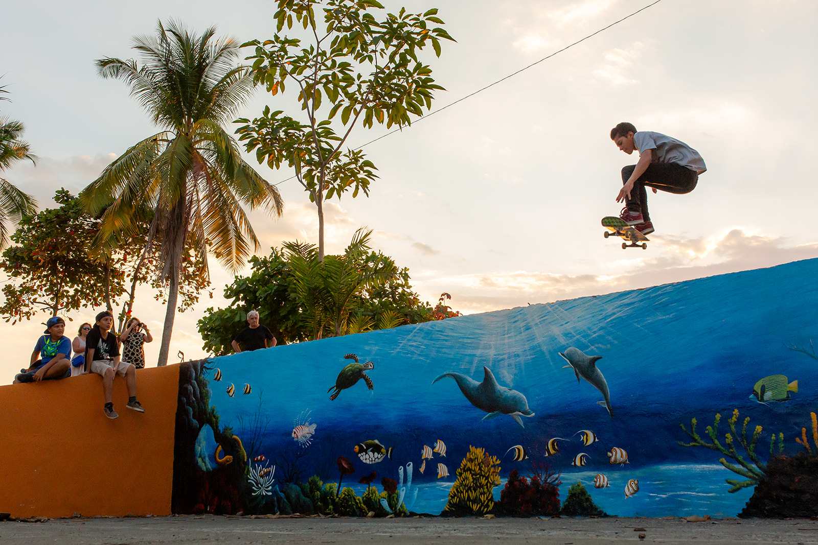 skateboarder jumping over wall in Quepos