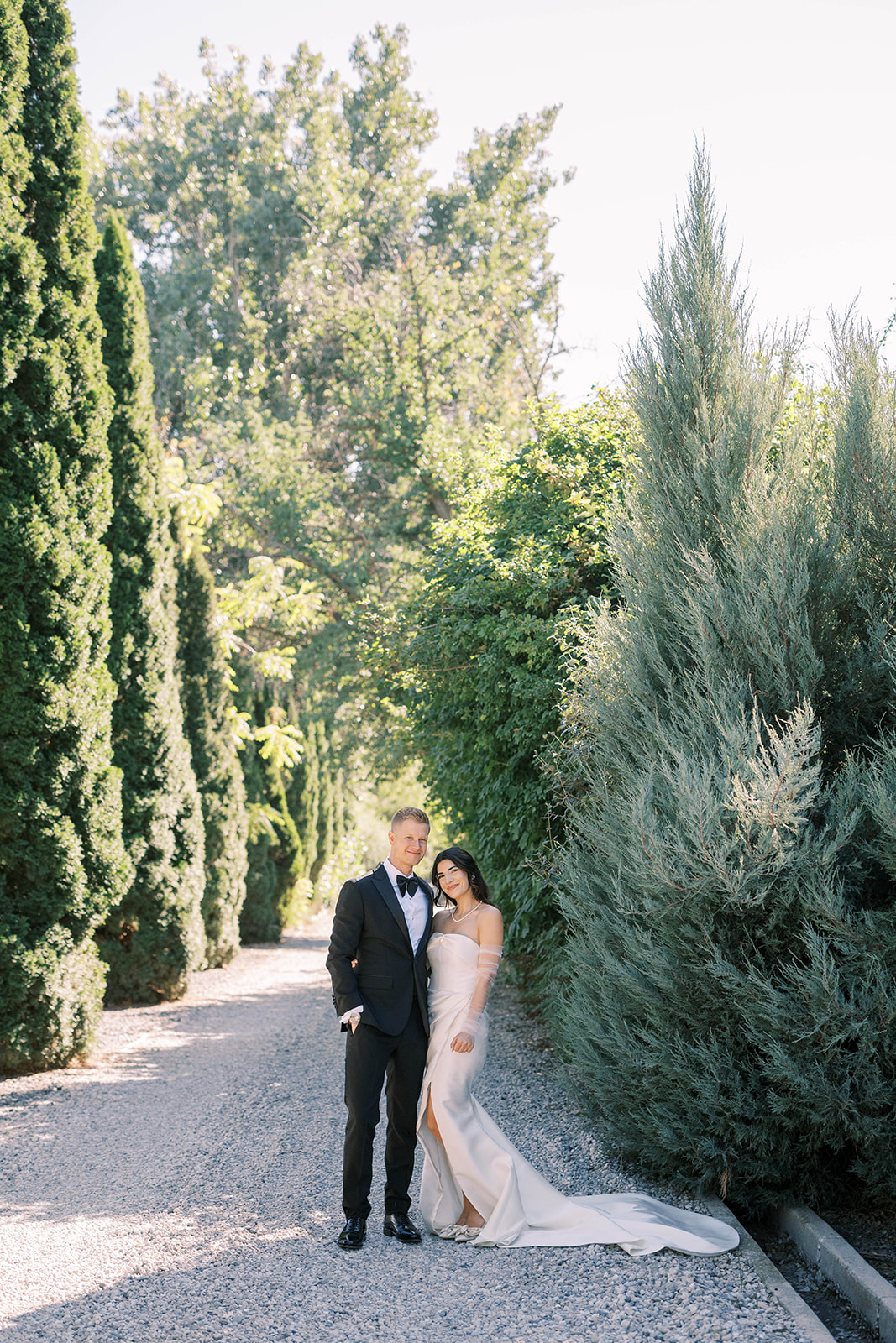 bride and groom stand amongst lush greenery during Cottage at Riverbend wedding