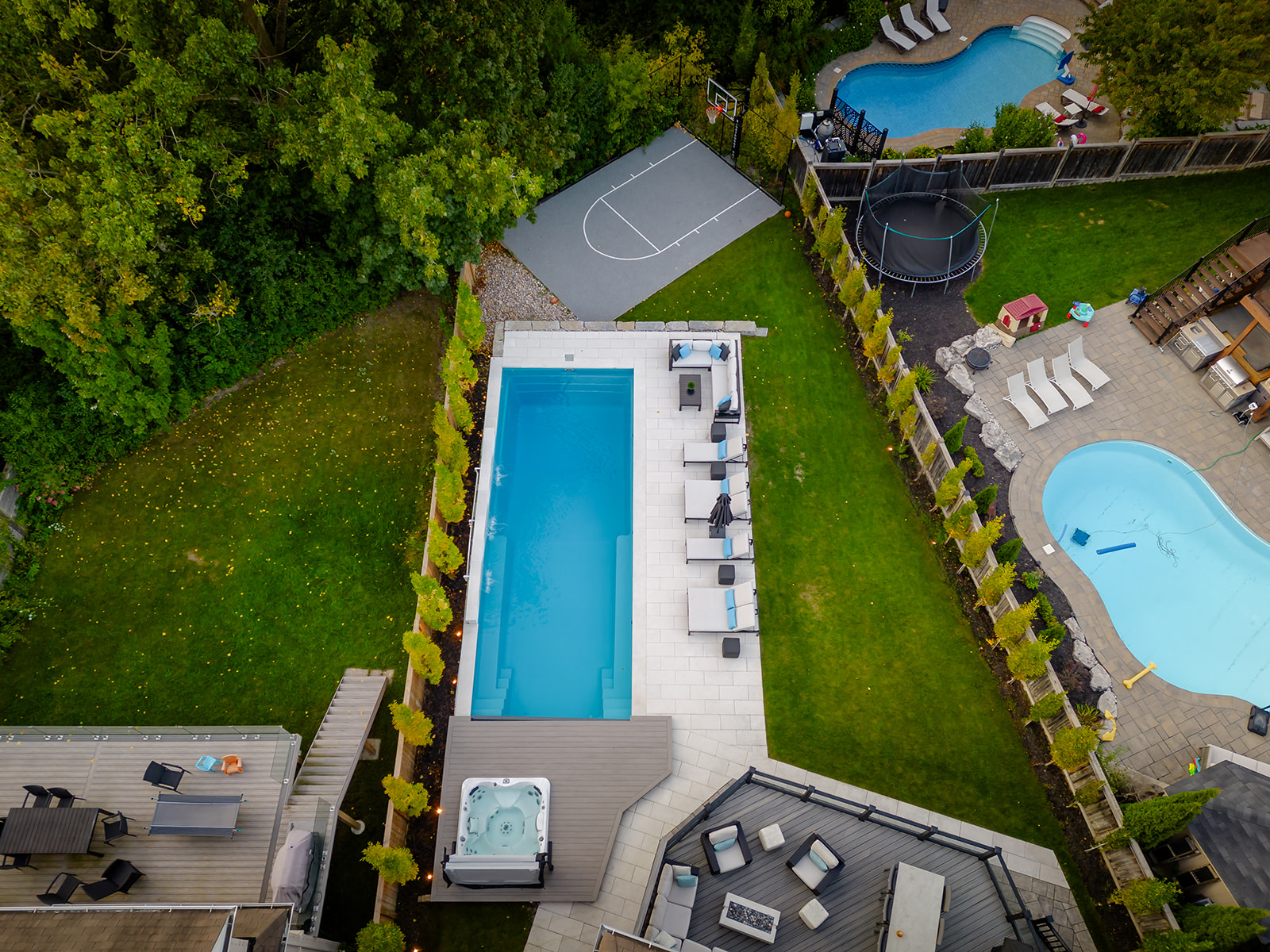A drone-shot of the backyard and the inground pool.