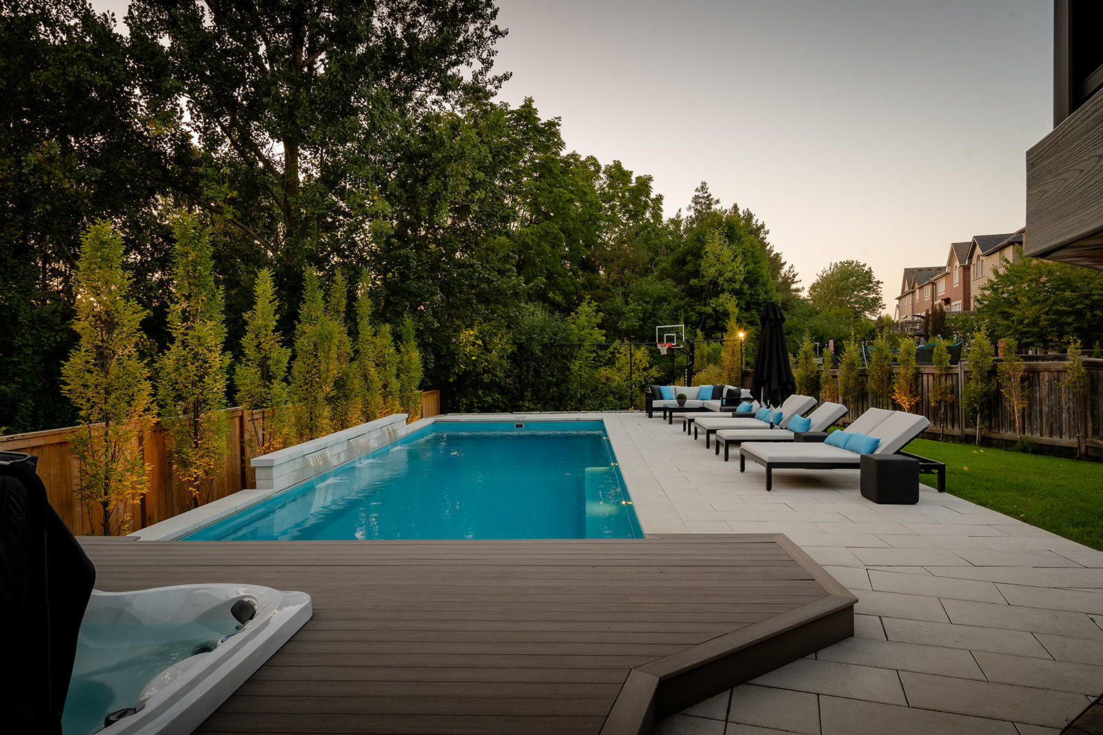An inground pool in the backyard with the raised deck in the foreground.