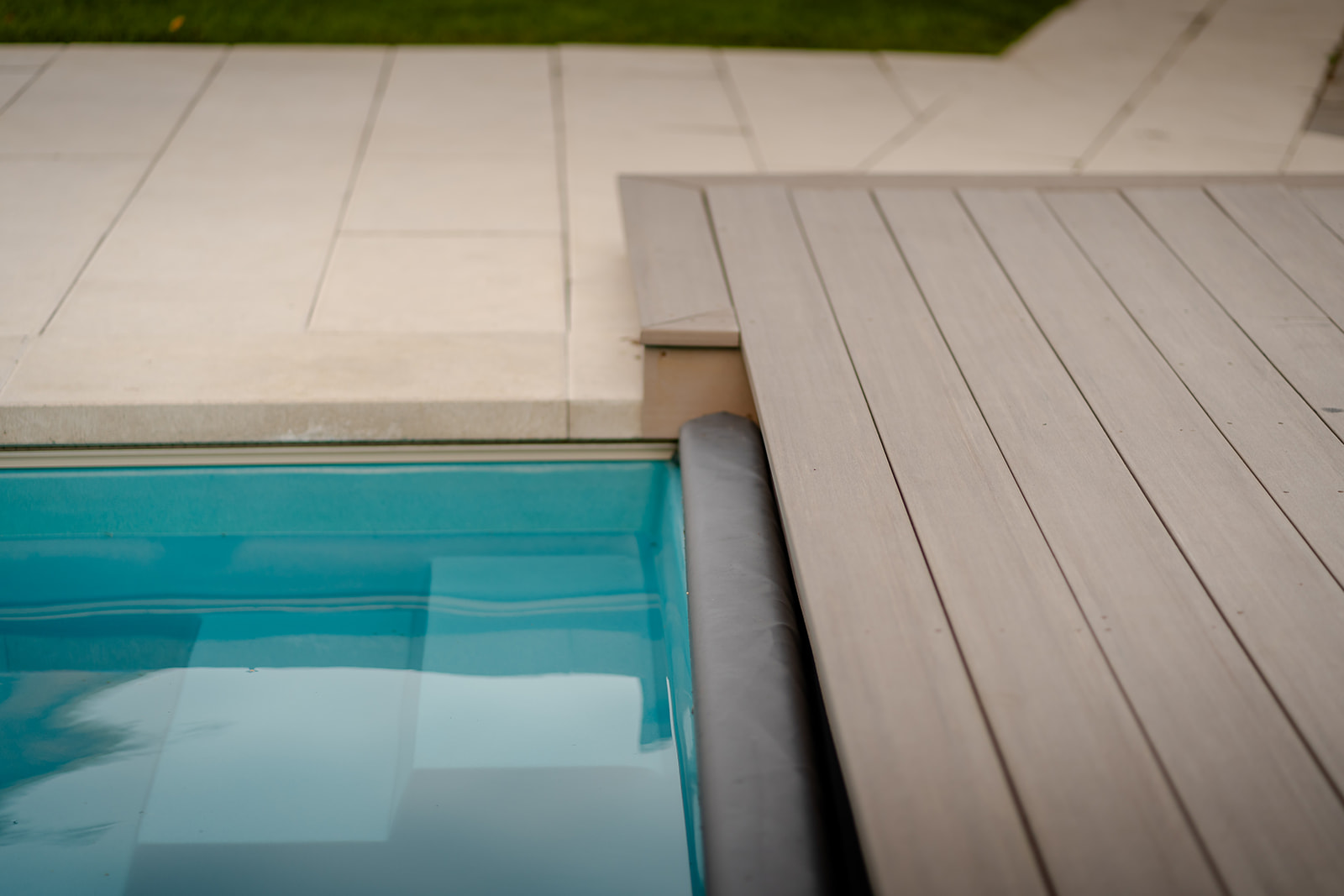 The edge of the raised deck connected to the inground pool.