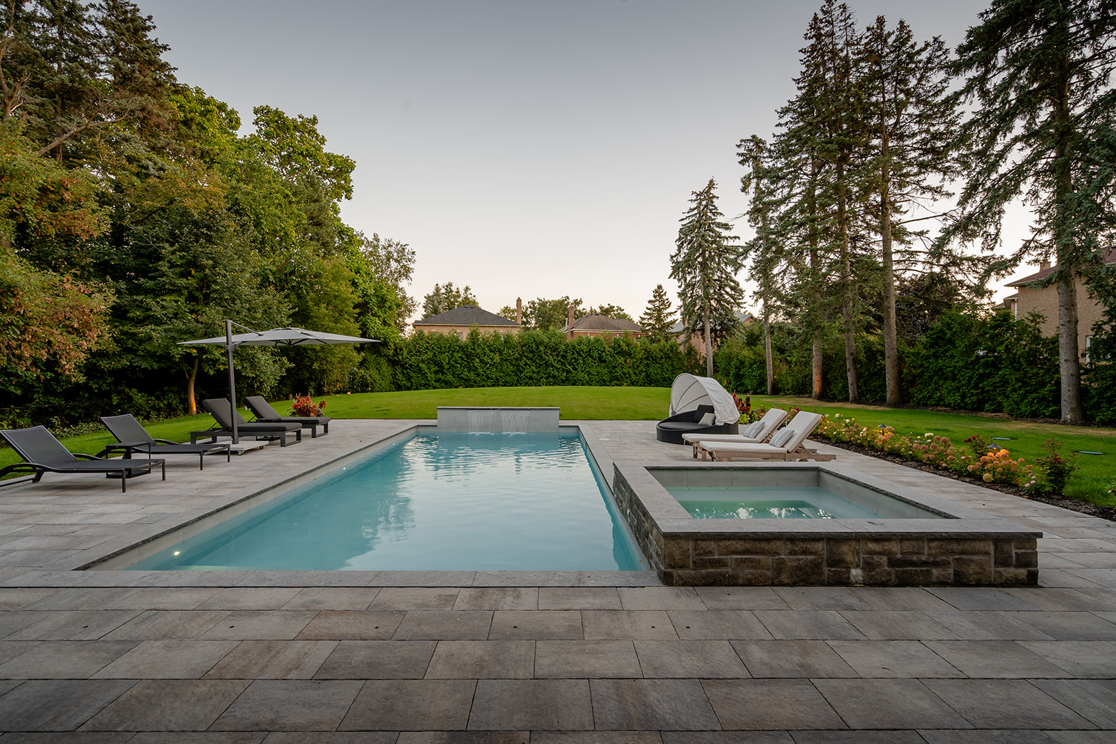 A backyard with an inground pool and the jacuzzi on the right.
