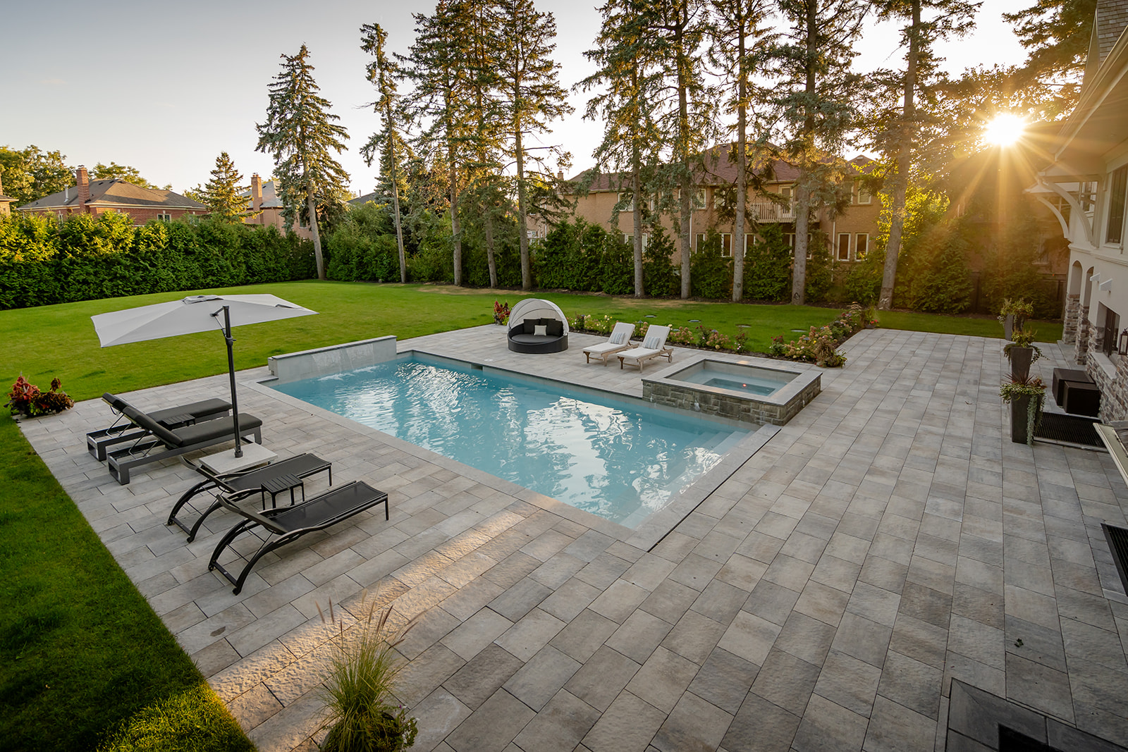 An inground pool with outdoor furniture on either side.