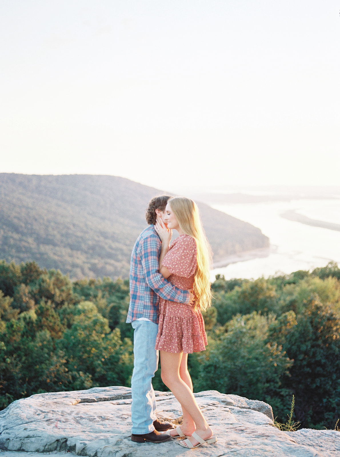 An engaged couple stand over a romantic view of the lake in Section, Alabama by Kelsey Dawn Photography