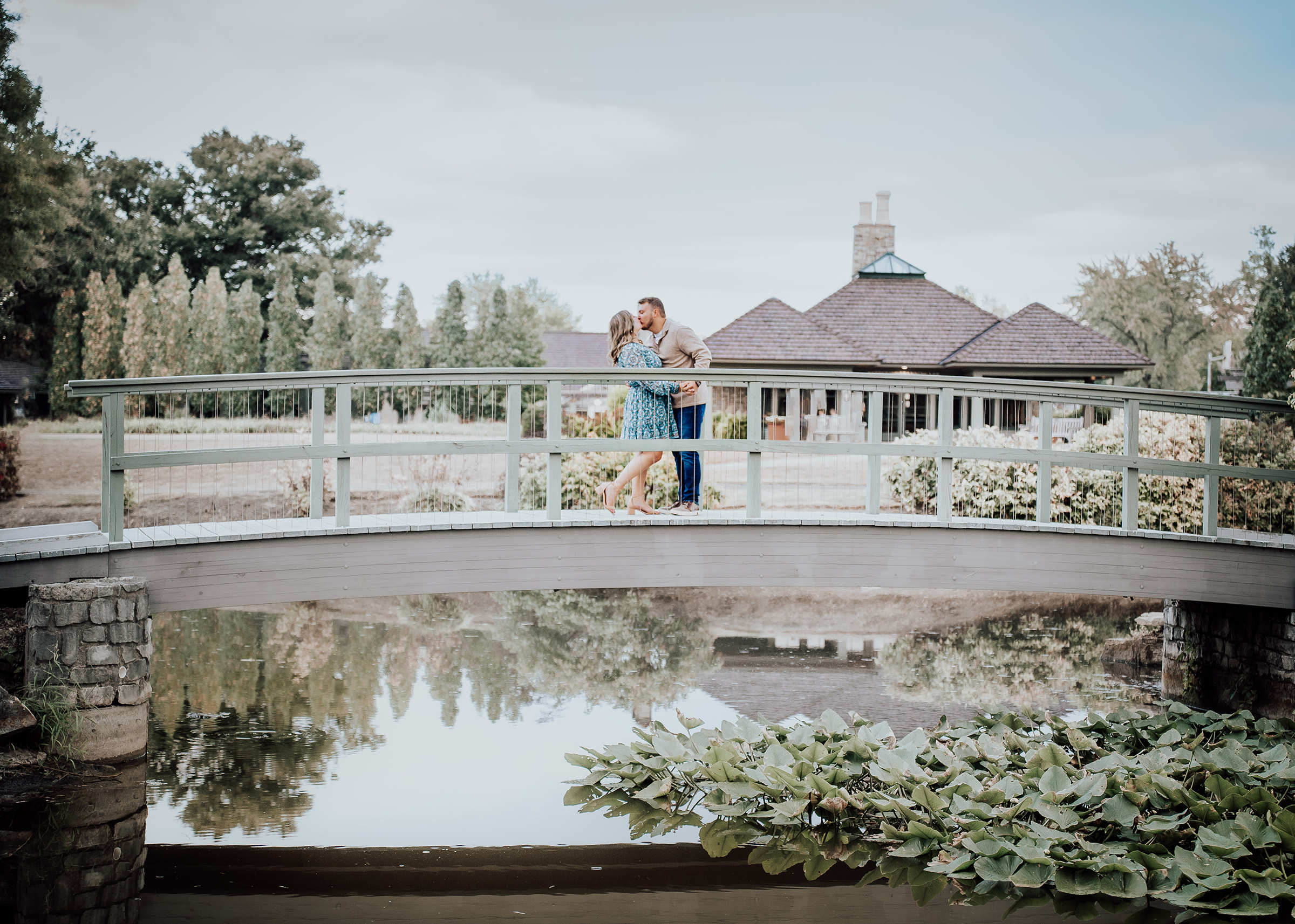 Couple kissing on bridge overlooking pond Cox Arboretum Dayton Ohio