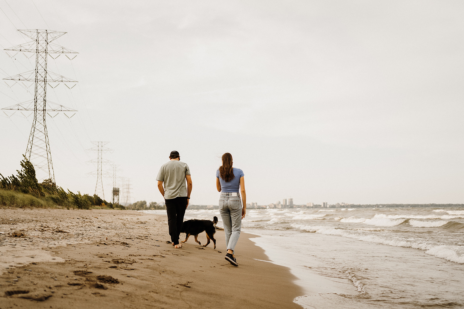 A man and woman walking down the beach together.