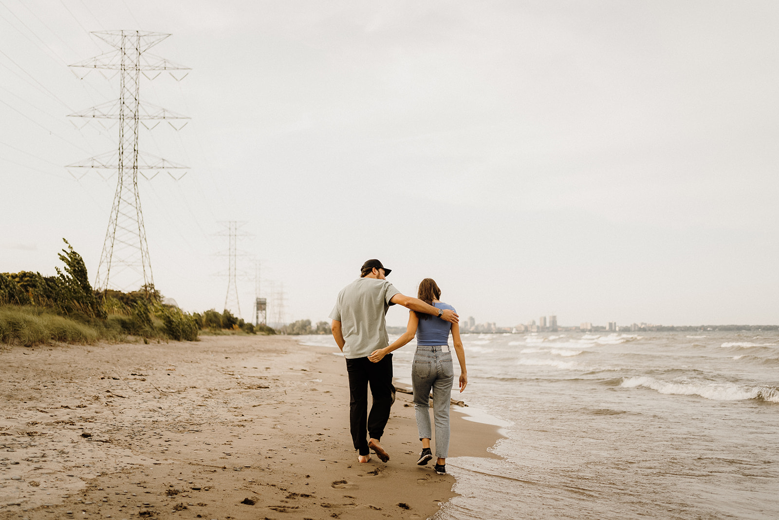 A man and woman walking down the beach together.