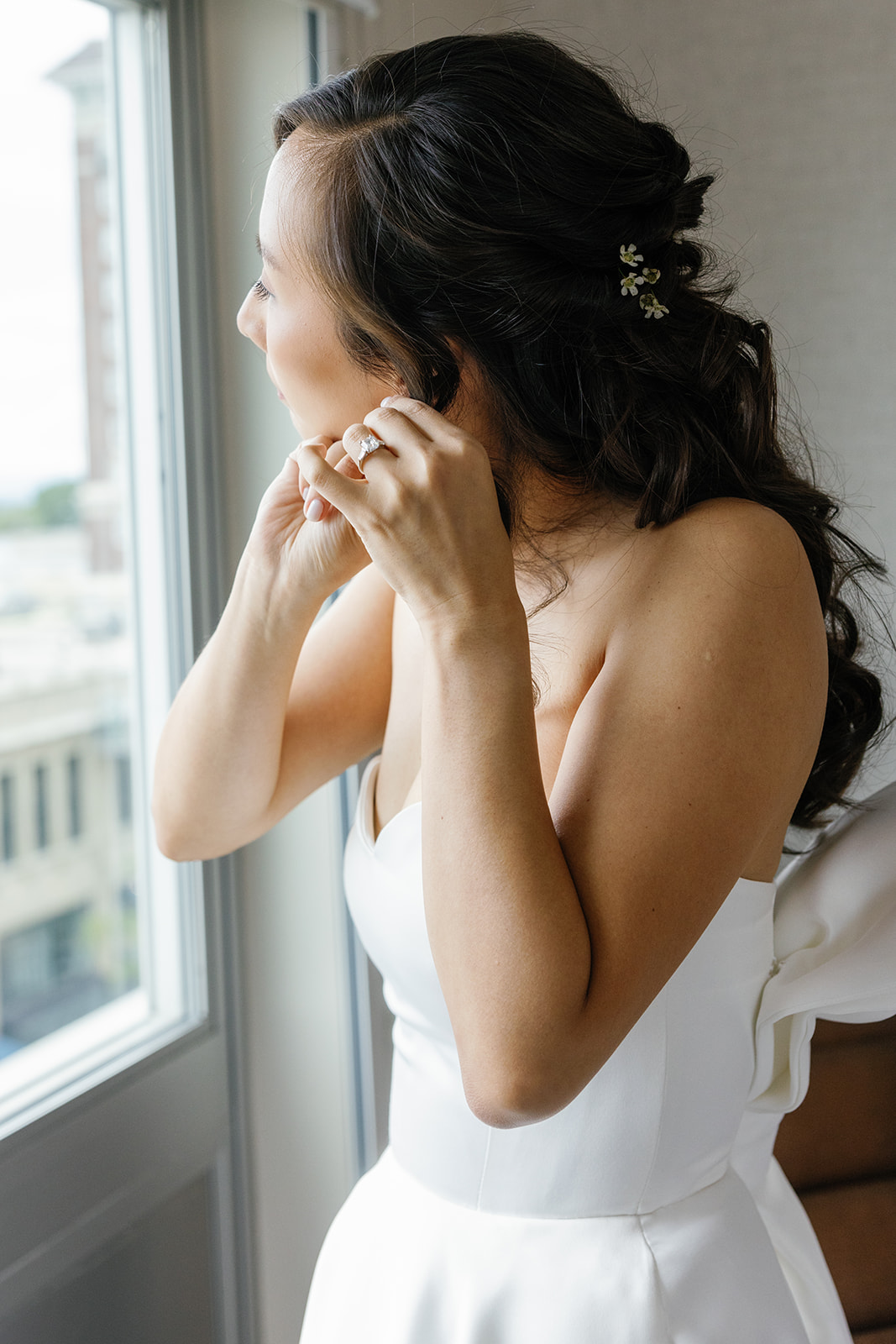 bride putting her pearl and diamond earrings in at Cambria suite