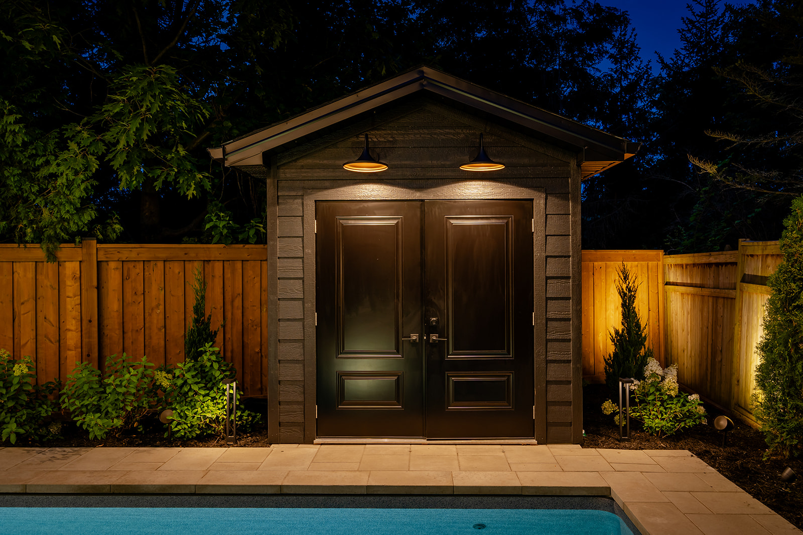 A pool house with lights on.