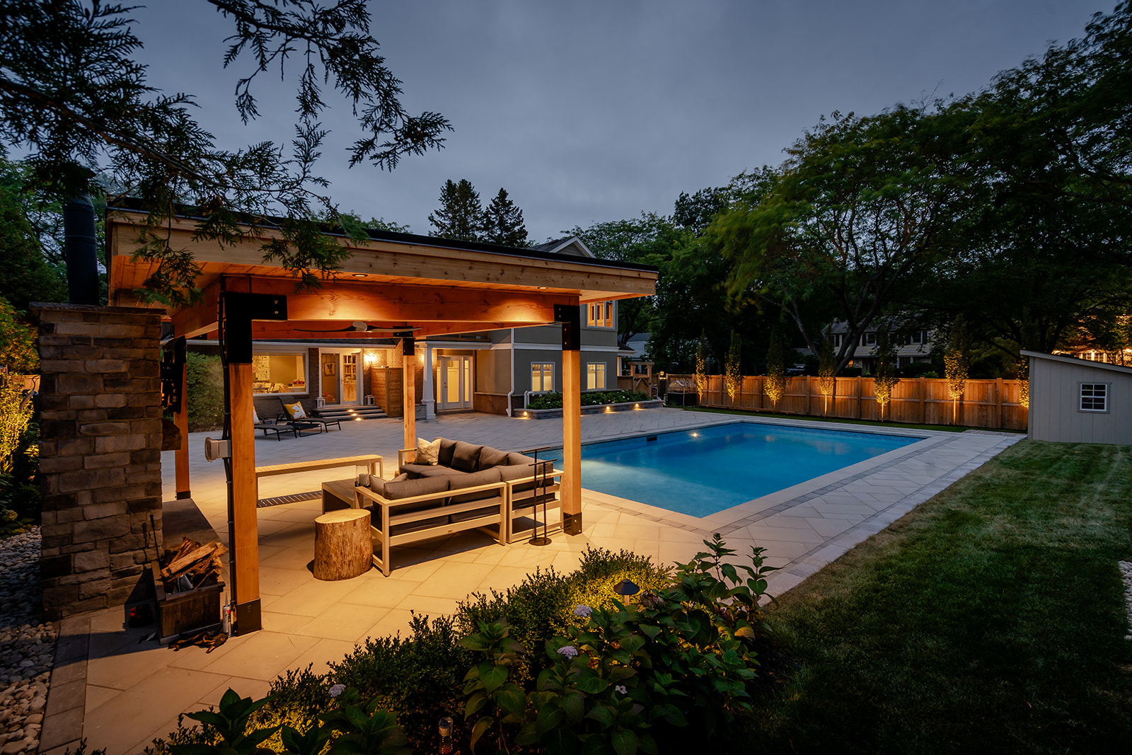 A gazebo with an outdoor patio underneath and the pool beside.