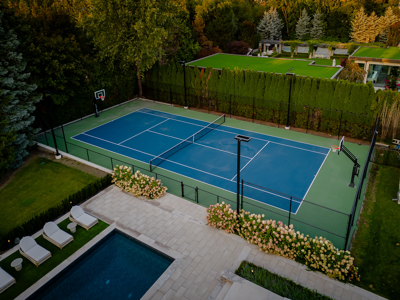 A drone shot of the backyard with the tennis court.