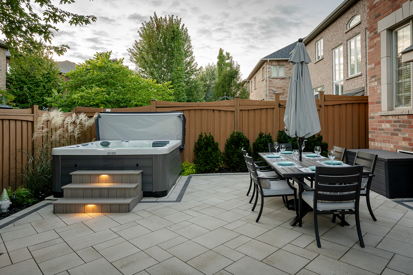 An above-ground jacuzzi with steps and an outdoor seating area to the side.