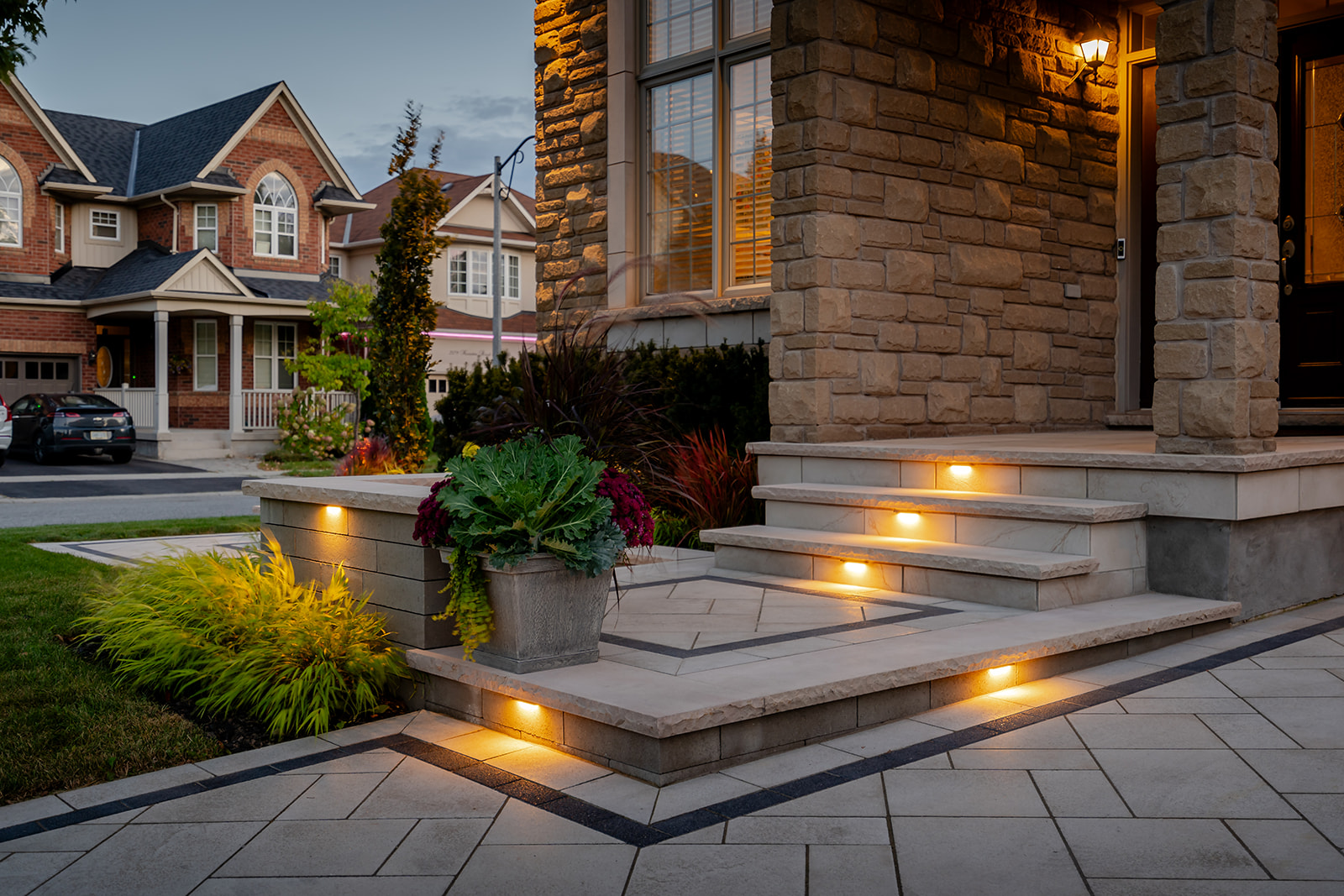 Patio stones leading up toward the house with lights on.