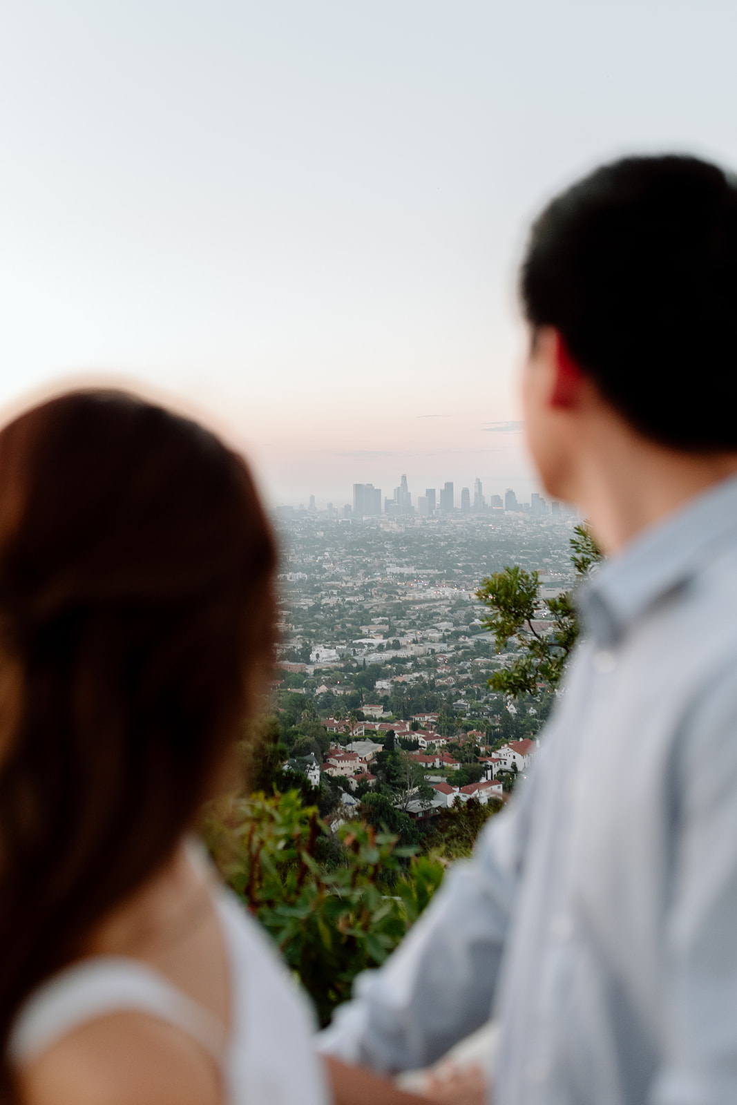 looking at the views sunrise engagement session with engagement couple at los angeles' griffith observatory