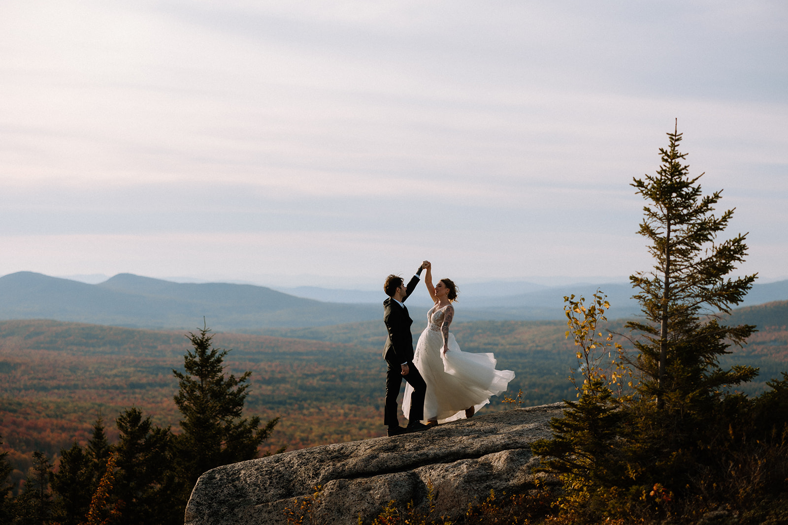 A couple who eloped in the White Mountains dance on the top of Middle Sugarloaf Mountain