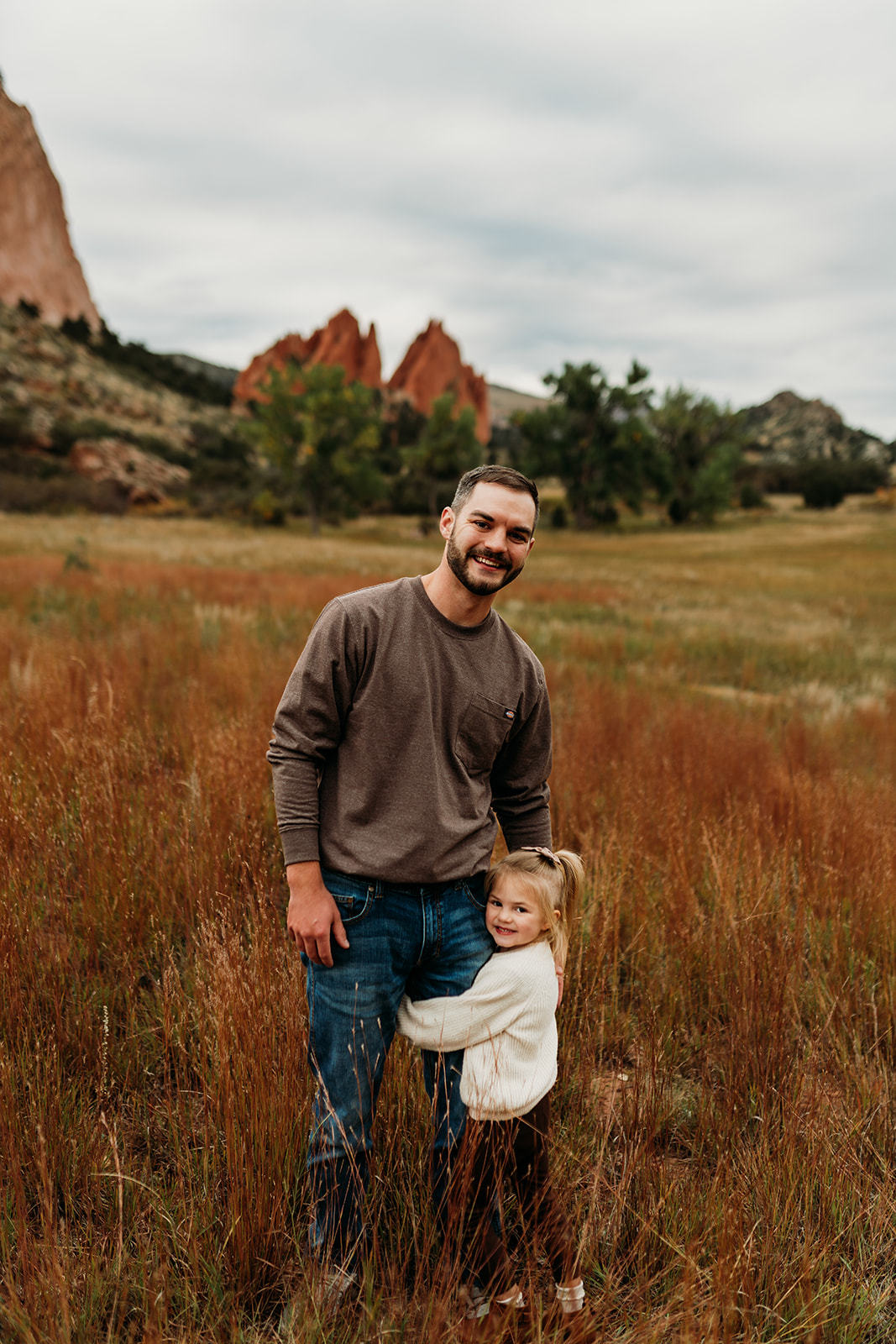 Daughter snuggling with her dad at Garden of the Gods Park in Colorado
