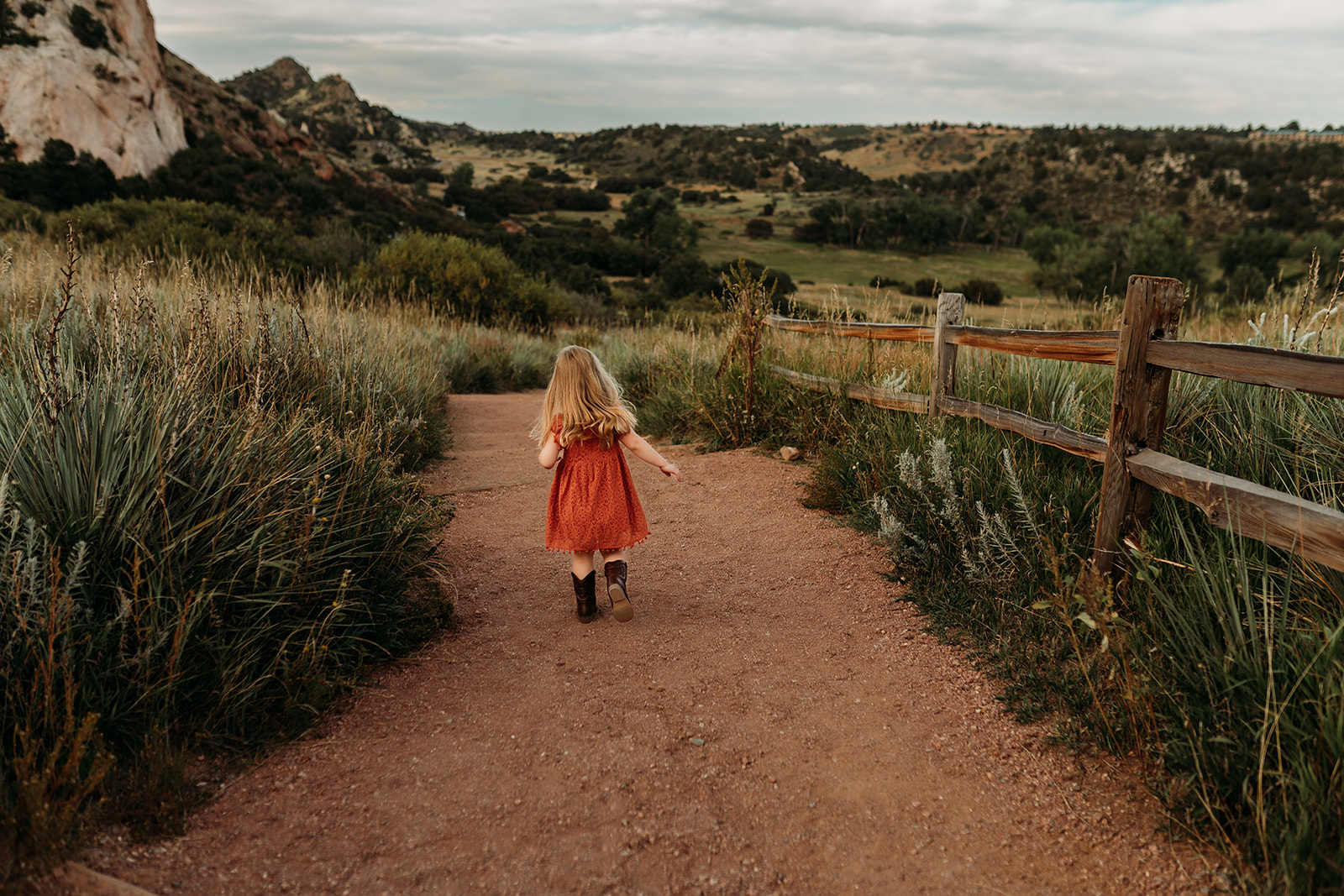 Little girl plays on one of the trails at Garden of the Gods while Heather Ann Photography takes her picture