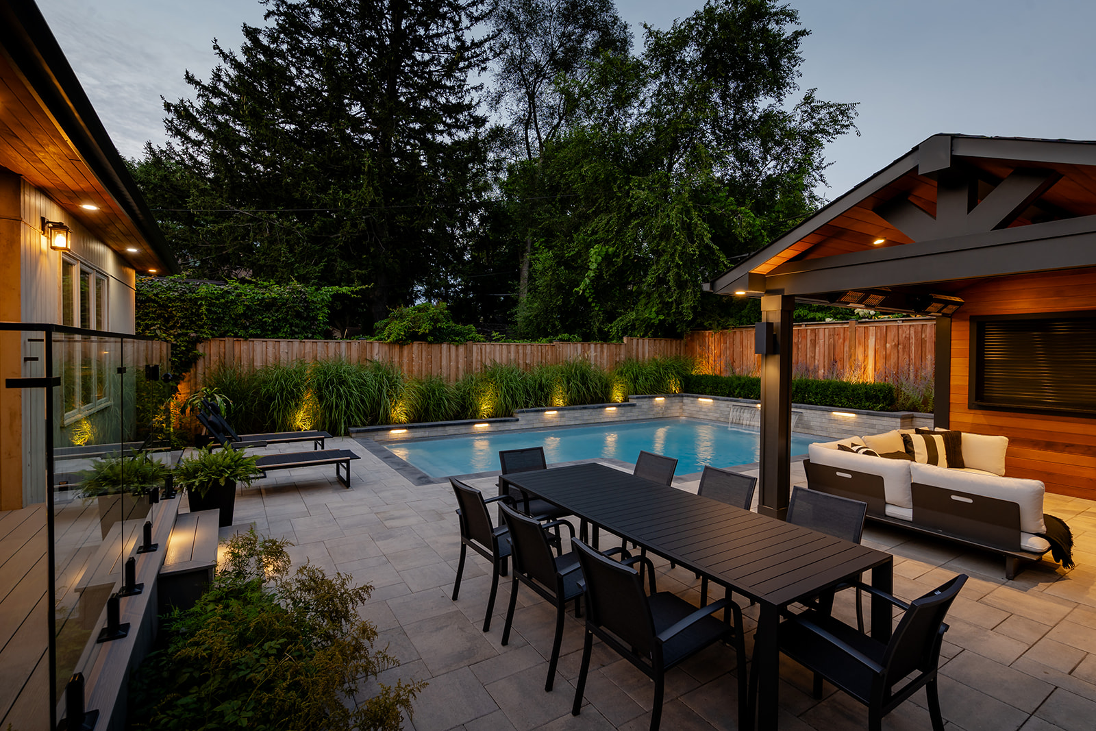 An outdoor patio set with an inground pool in the background.