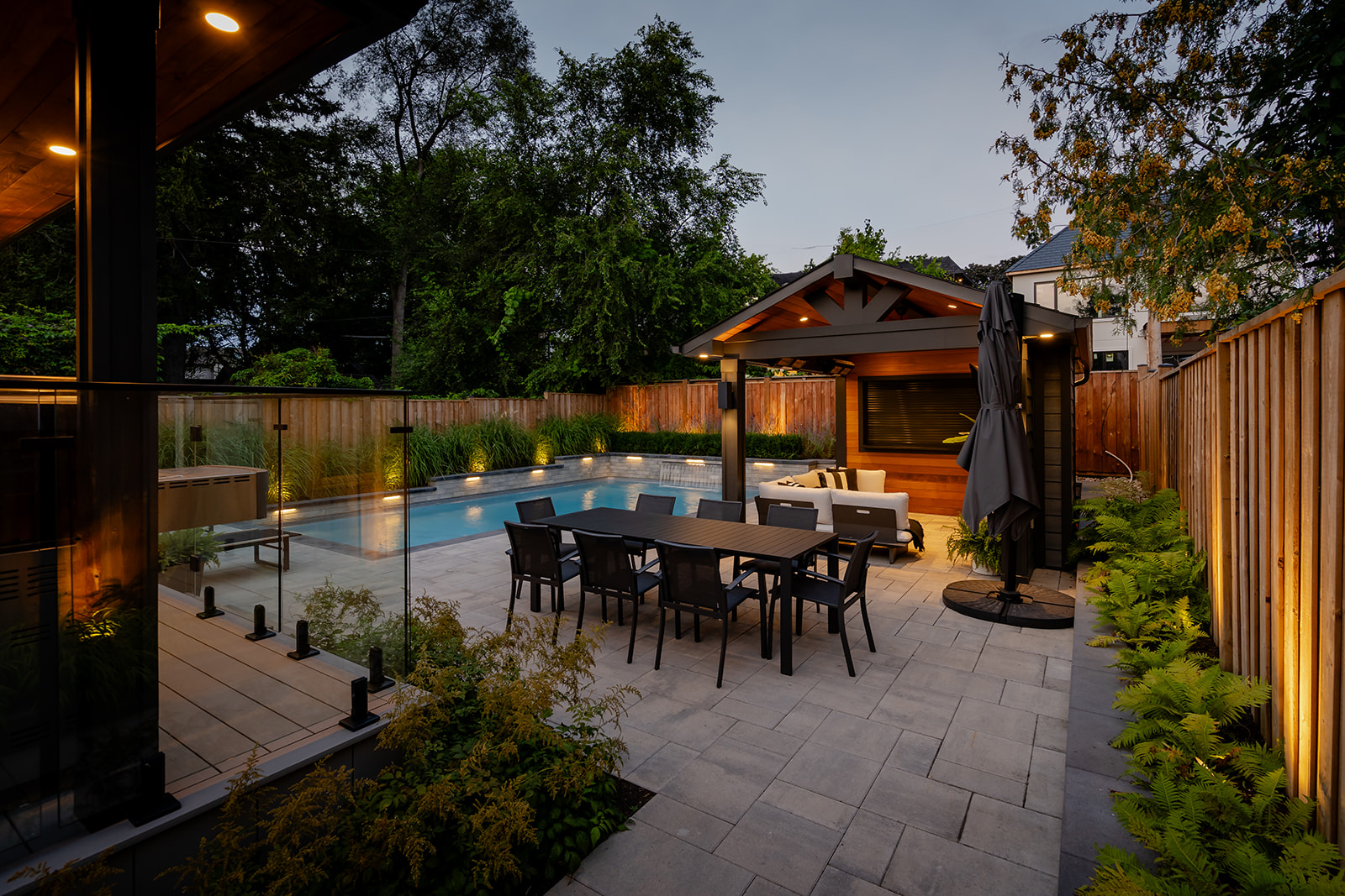 An outdoor patio set with an inground pool in the background.