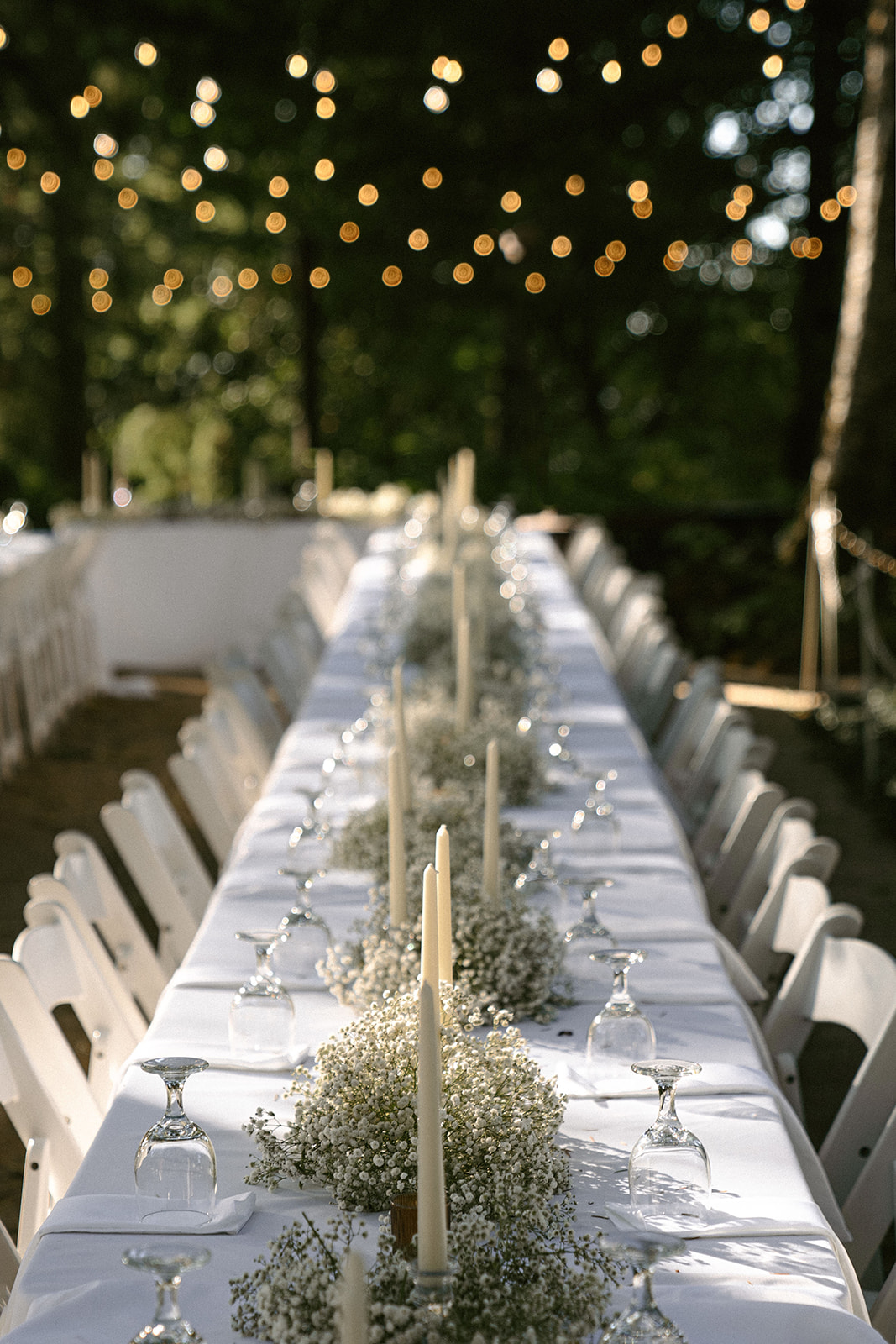 Modern white baby's breath florals, decor, and taper candles for a white tablscape at Bridal Veil Falls