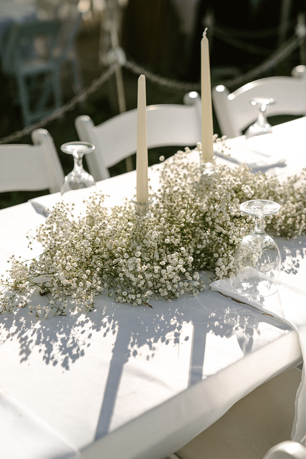 Modern white baby's breath florals, decor, and taper candles for a white tablscape at Bridal Veil Falls