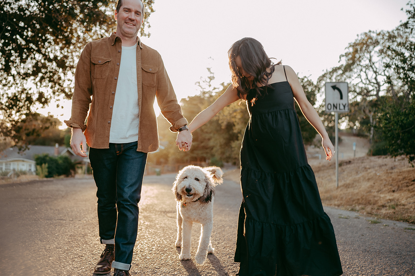 Husband and pregnant wife walking with dog for maternity photo session