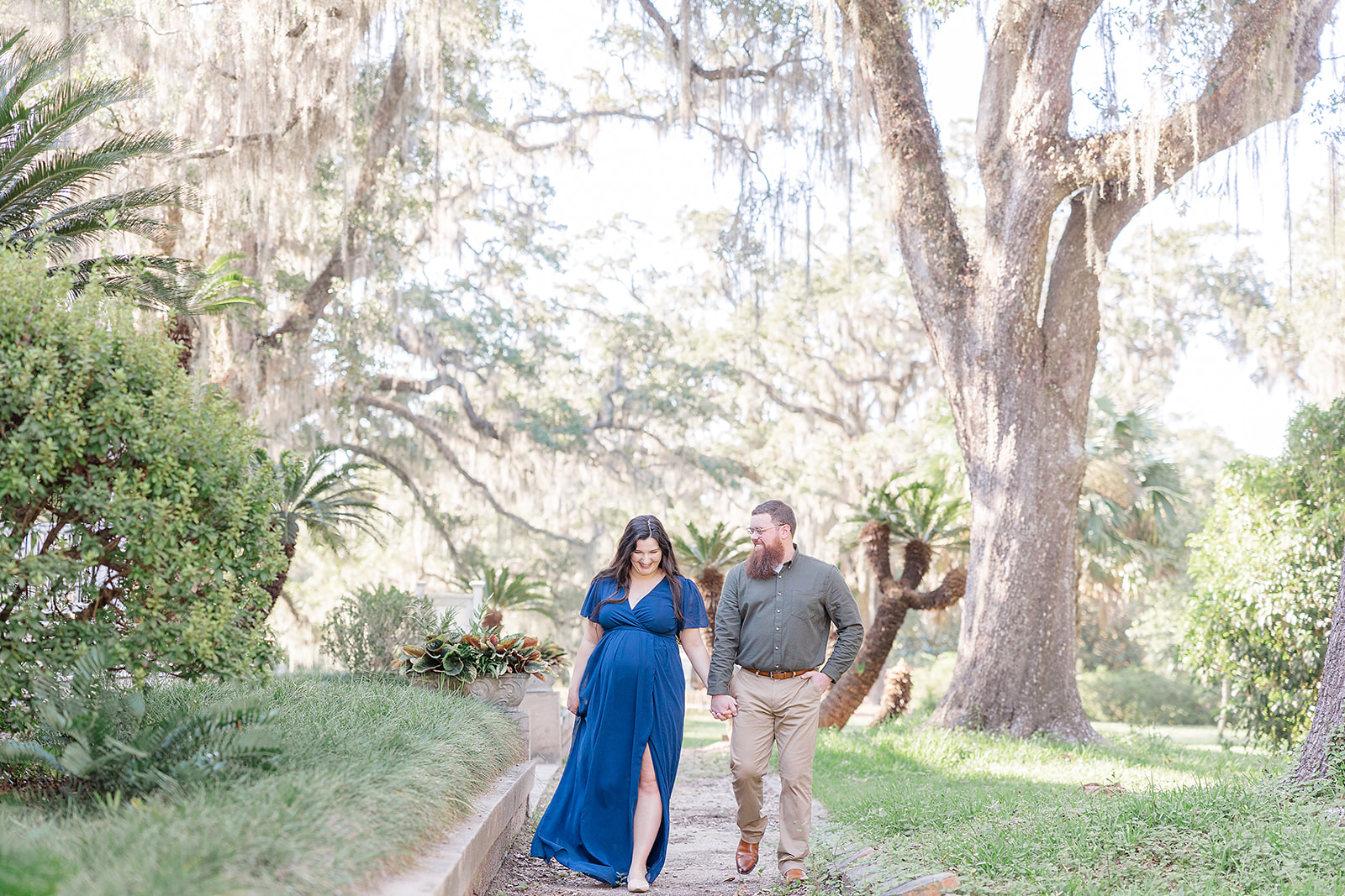 Expectant Mom and Dad walking along a gravel sidewalk