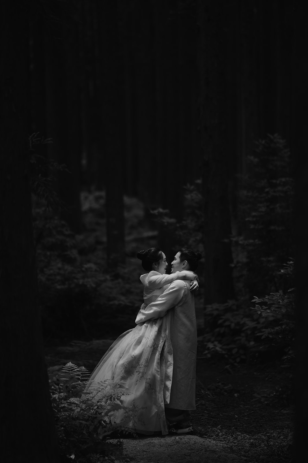 A pre-wedding photo of a couple hugging in the woods in Korea.