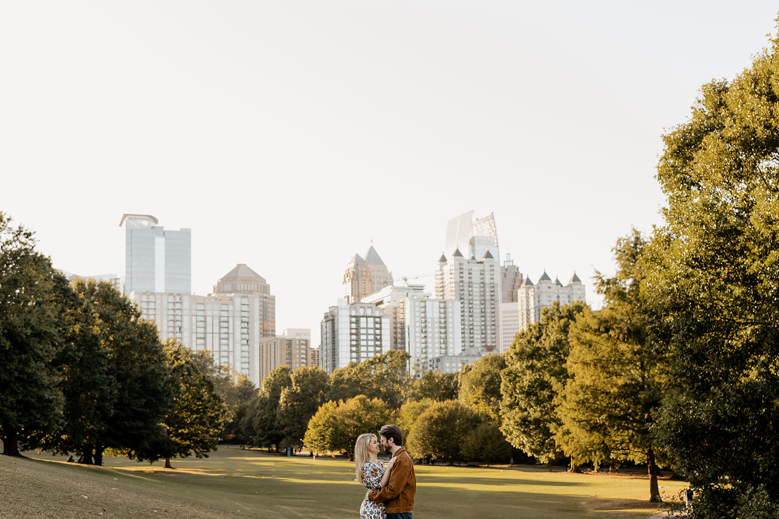 A couple embraces in the golden glow of sunset at Piedmont Park.
