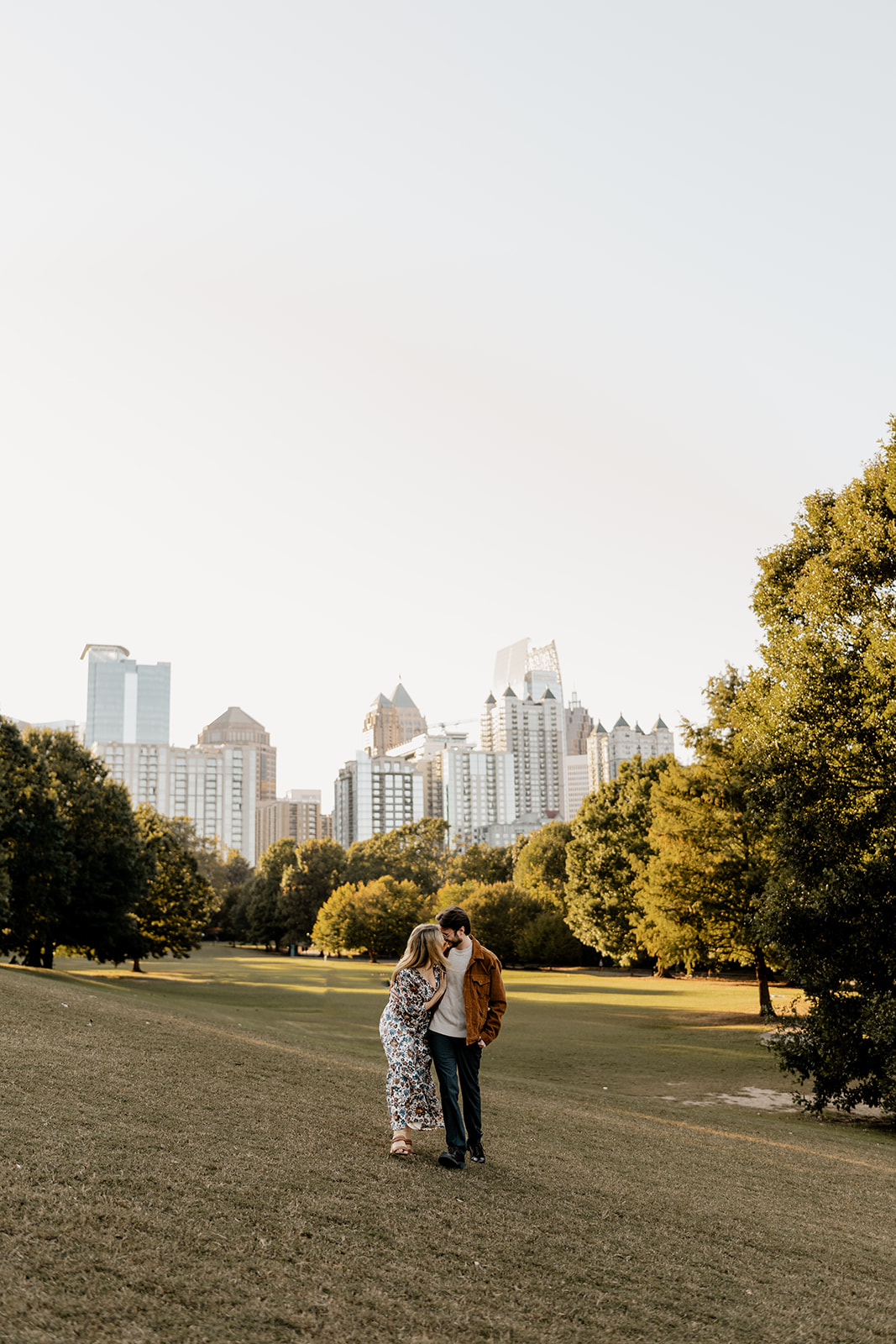 A couple embraces in the golden glow of sunset at Piedmont Park.
