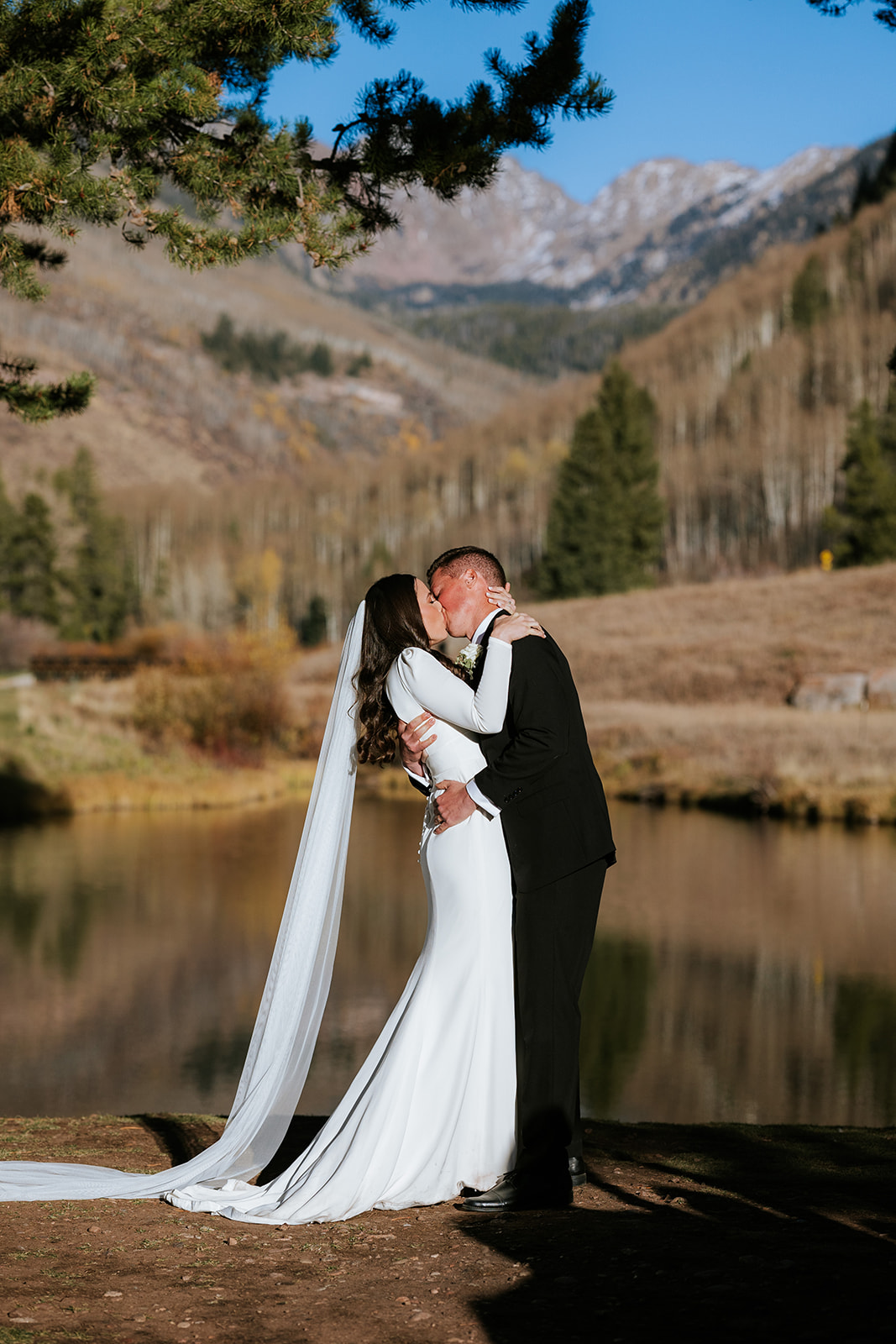 A bride and groom kiss at the end of their ceremony on the wedding island at Vail Golf Club.