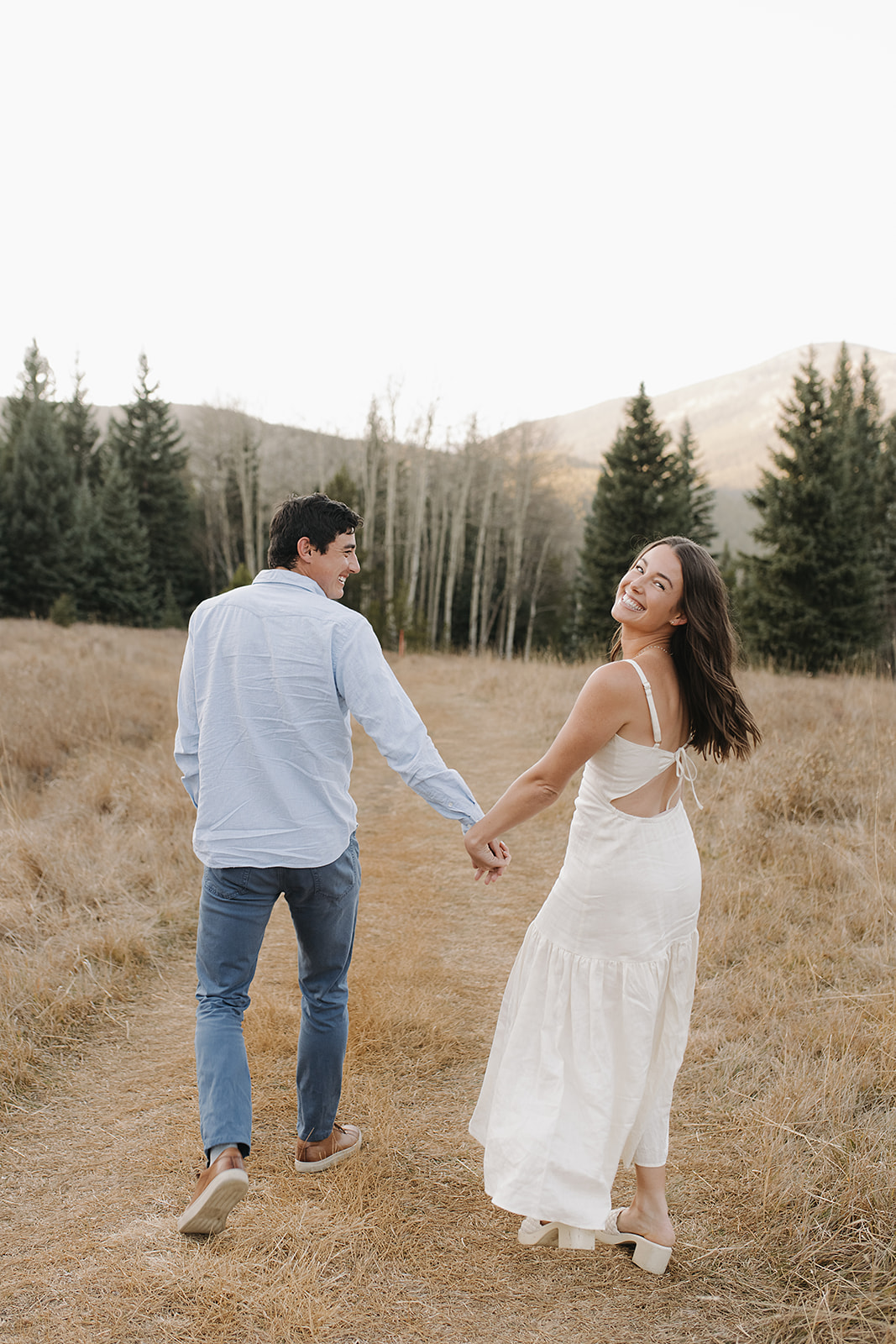 Candid laughing and smiling pose for engagement session in Evergreen, Colorado mountains