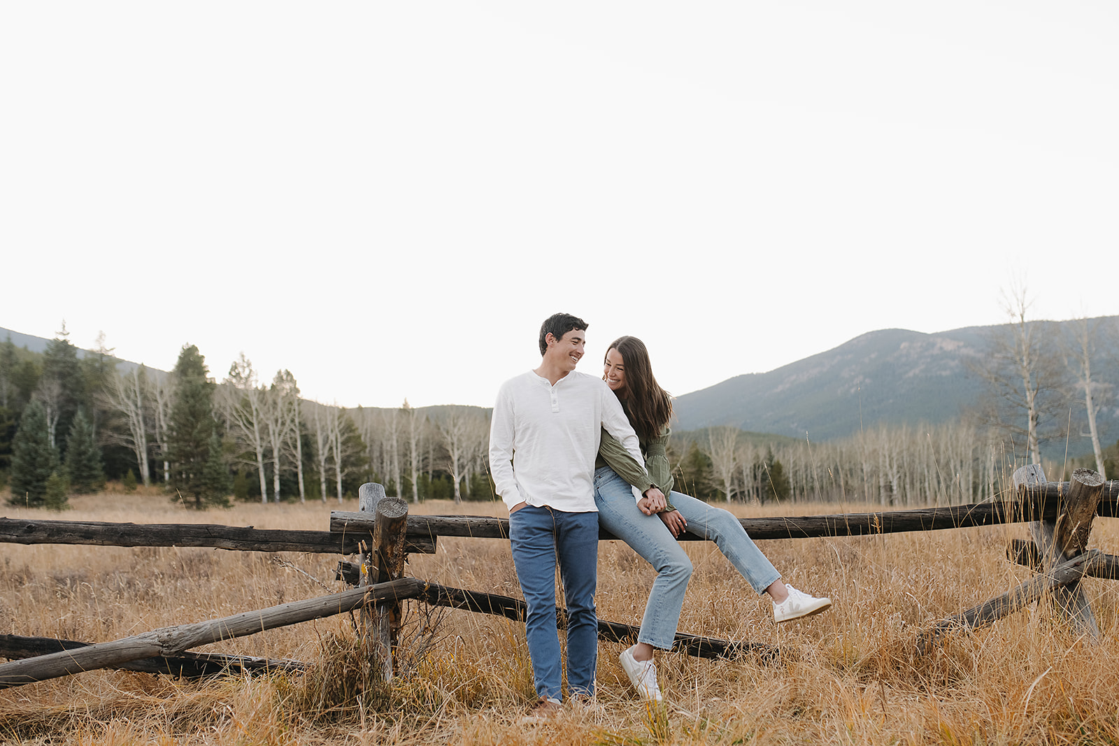 In-love newly engaged Colorado couple taking engagement portraits in mountain evergreen
