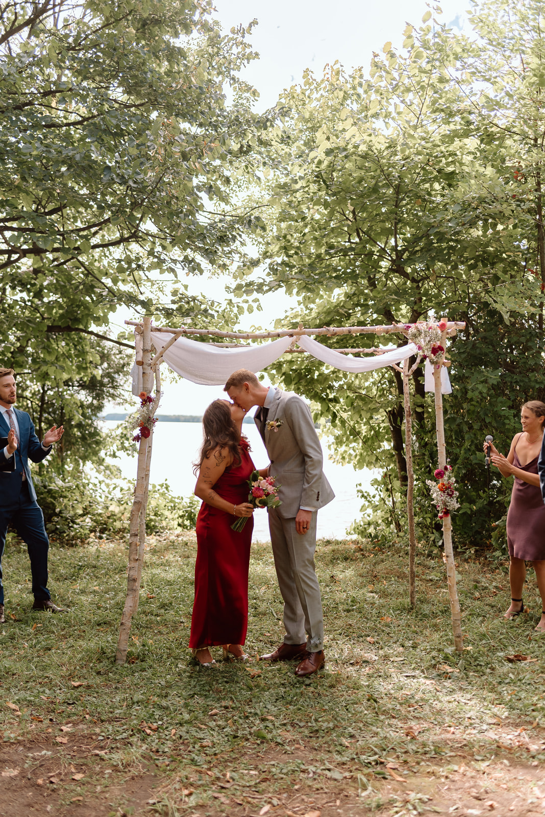a bride and groom share their first kiss during their wedding at camp couchiching.