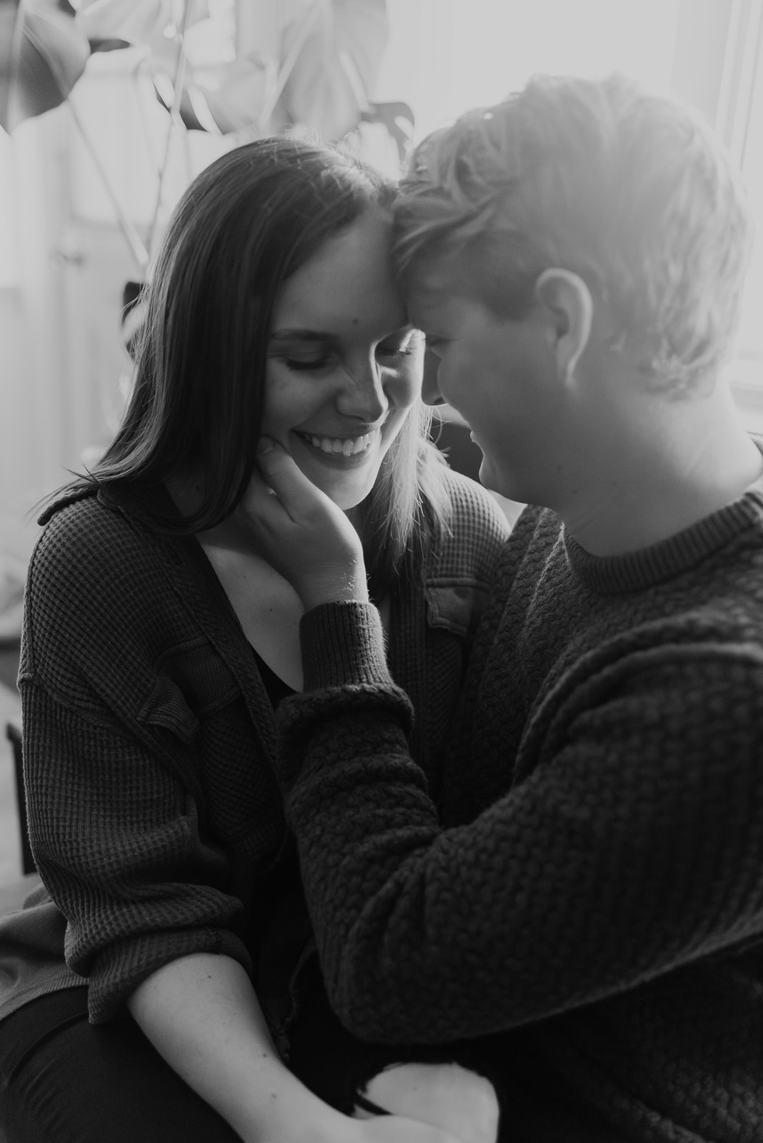 An engaged couple in their home during an engagement session. 