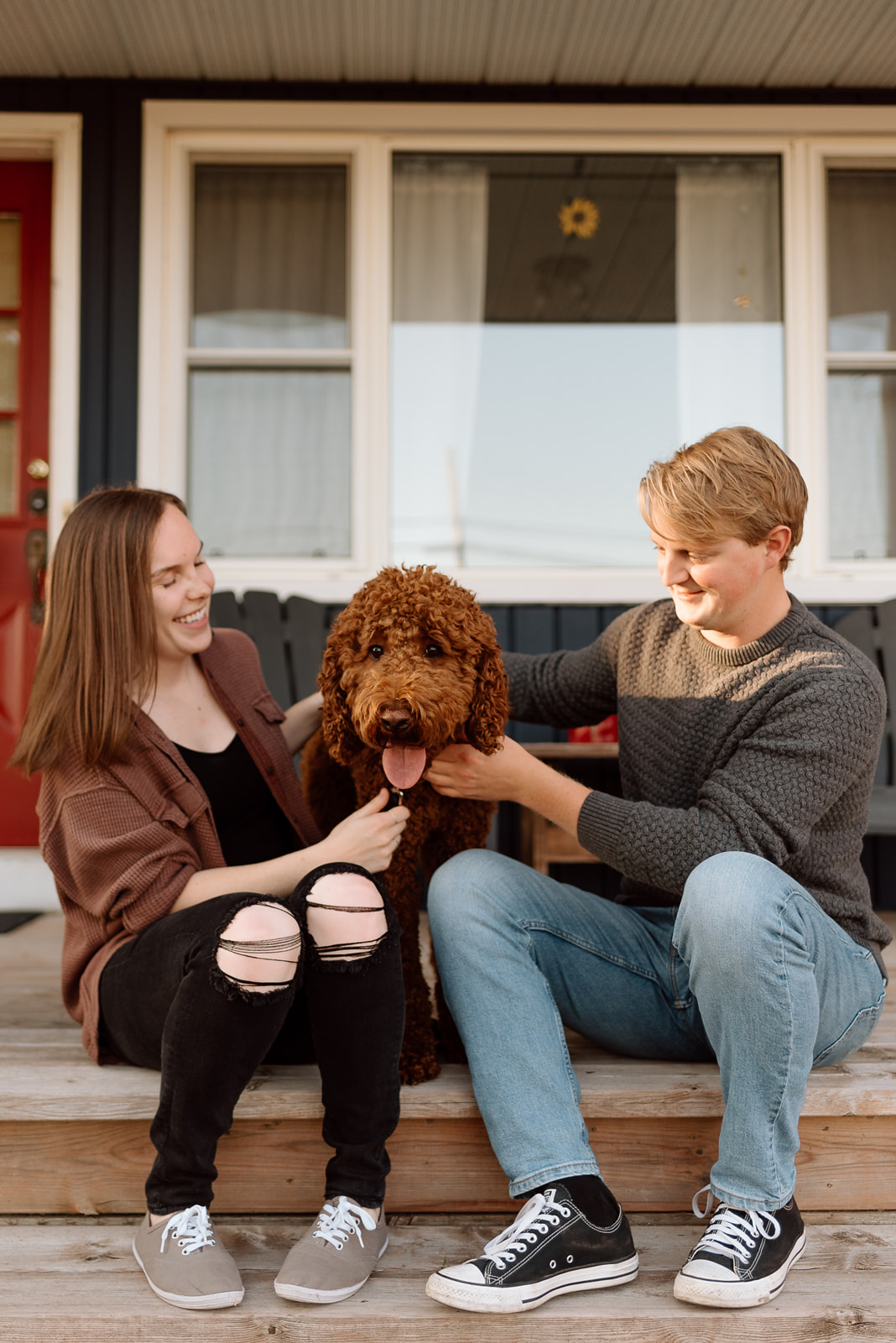 An engaged couple and their dog outside their home near Barrie, Ontario. 