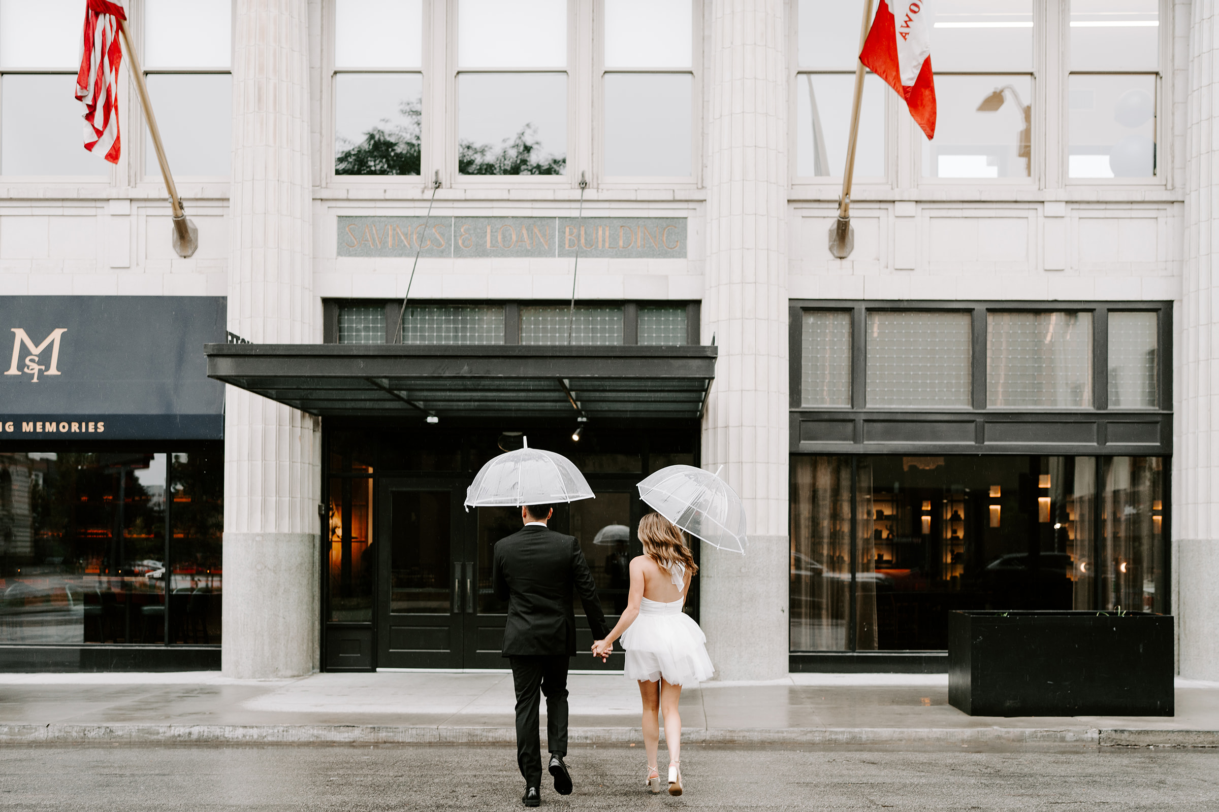 Engagement photos running in the rain at the Surety Hotel in Downtown Des Moines