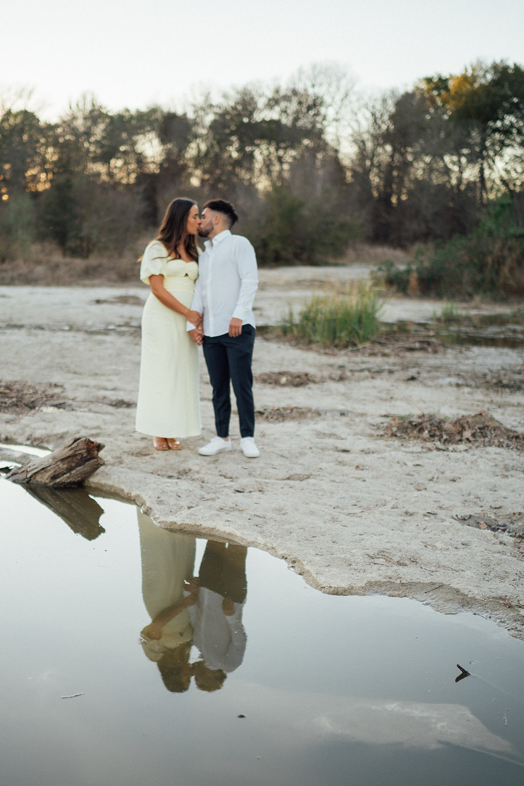 Couple embracing on a boulder during a engagement photography session at McKinney Falls