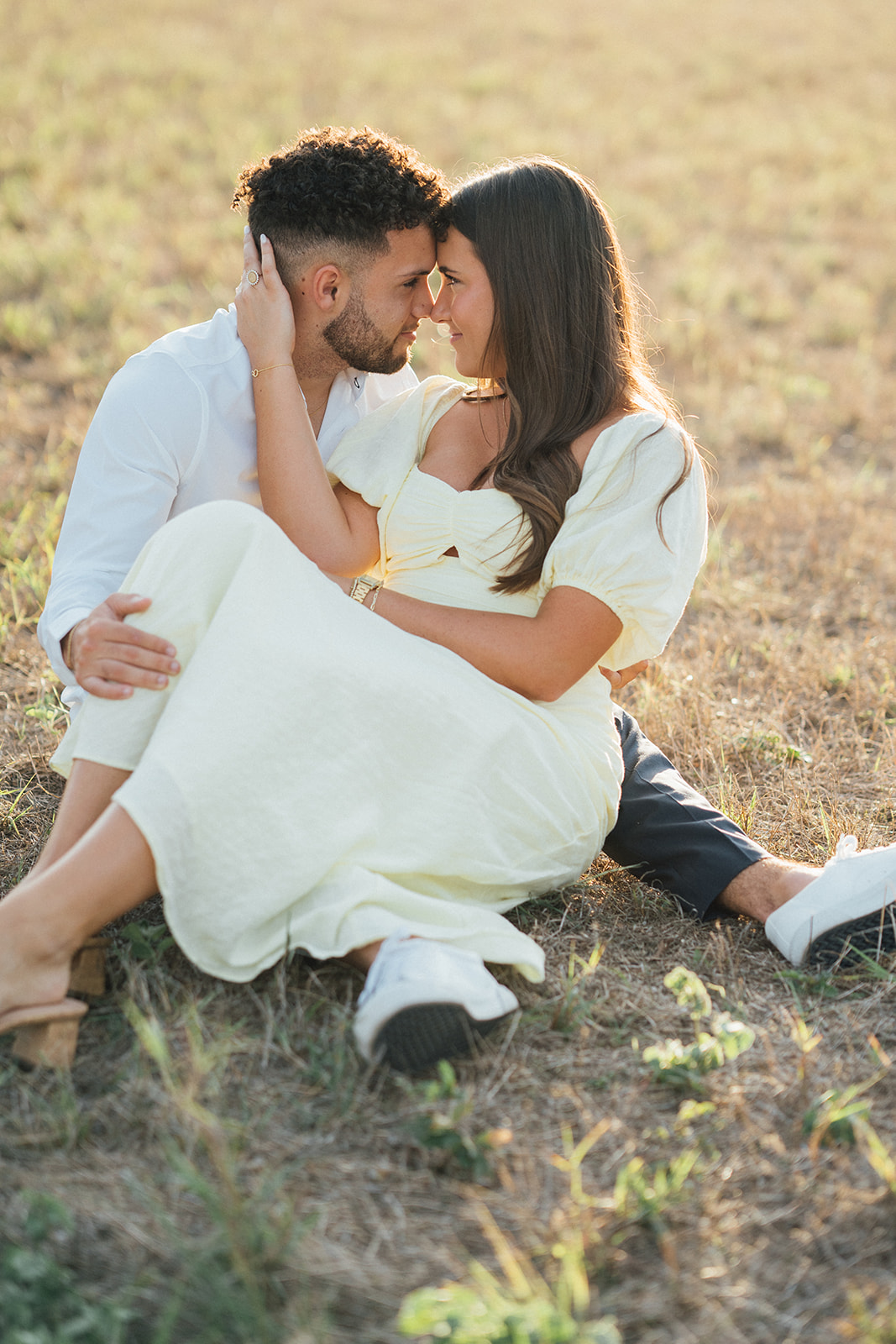 A couple embracing while sitting in a field at McKinney Falls
