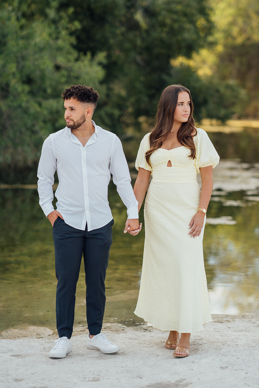 A couple holding hands during their engagement photography session at McKinney Falls