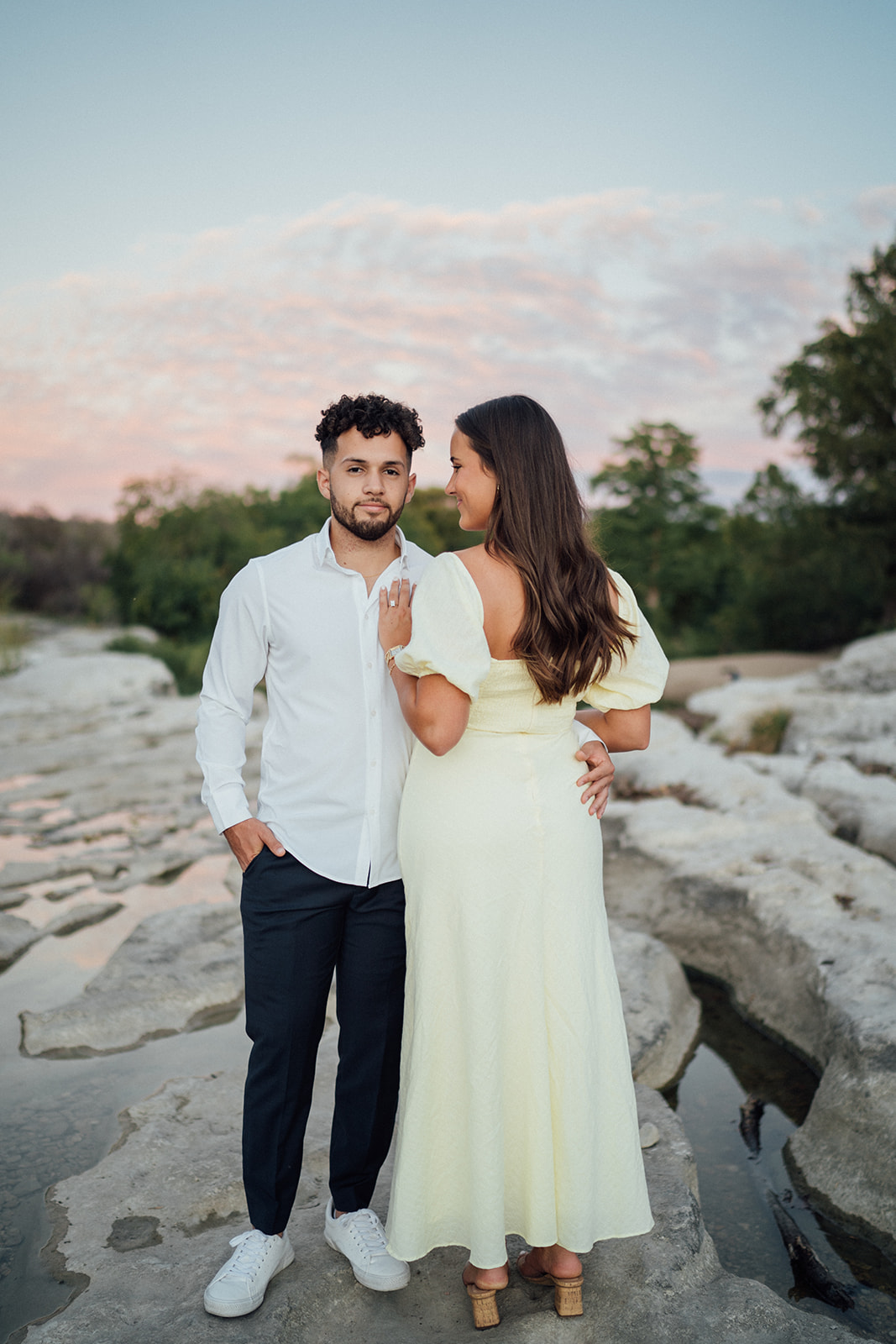 The sunsetting while a couple are taking engagement photos at McKinney Falls