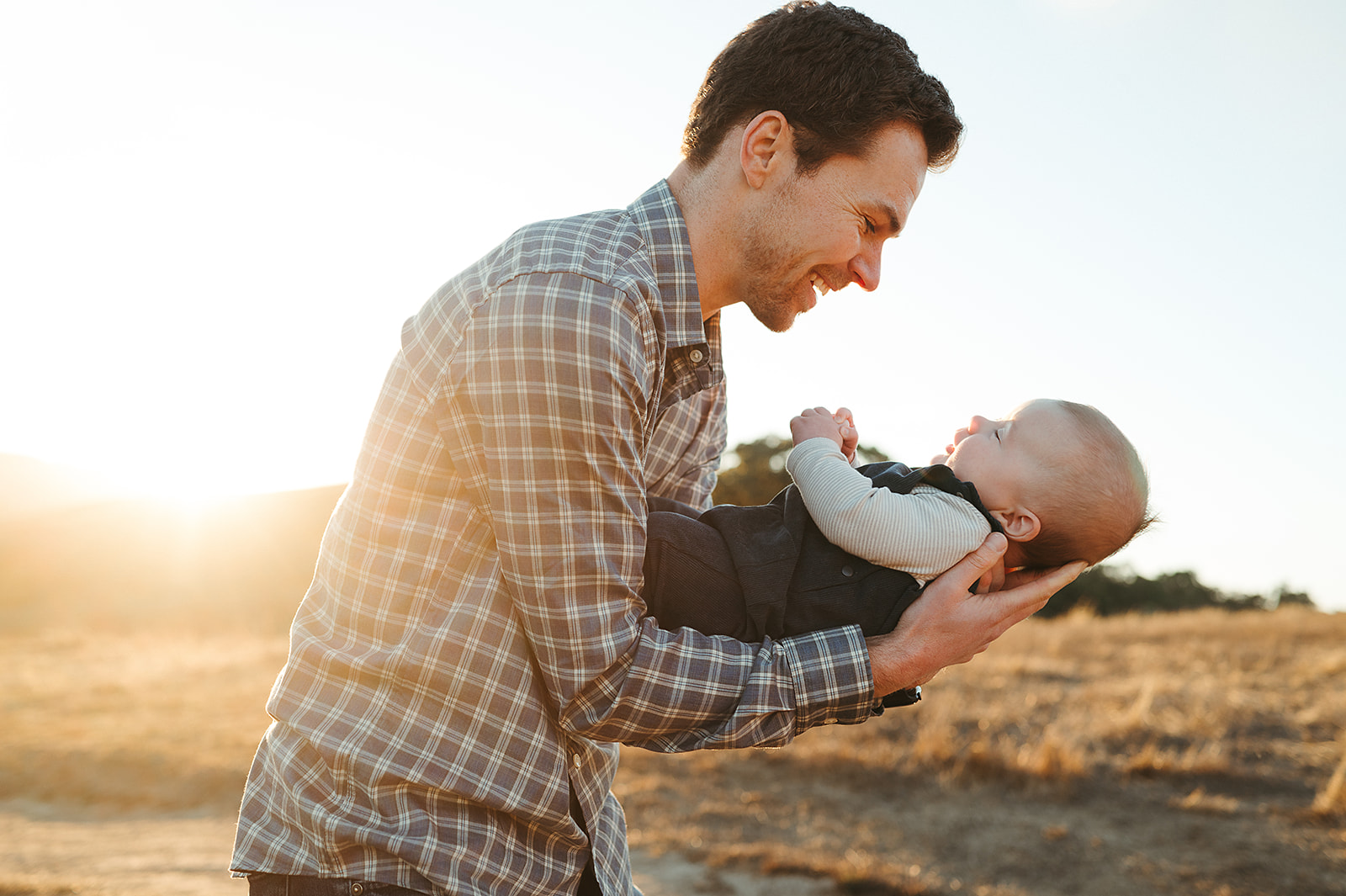 Dad smiling down at baby during photo session at Helen Putnam Park in Petaluma, California by Sunshine Lady Photography