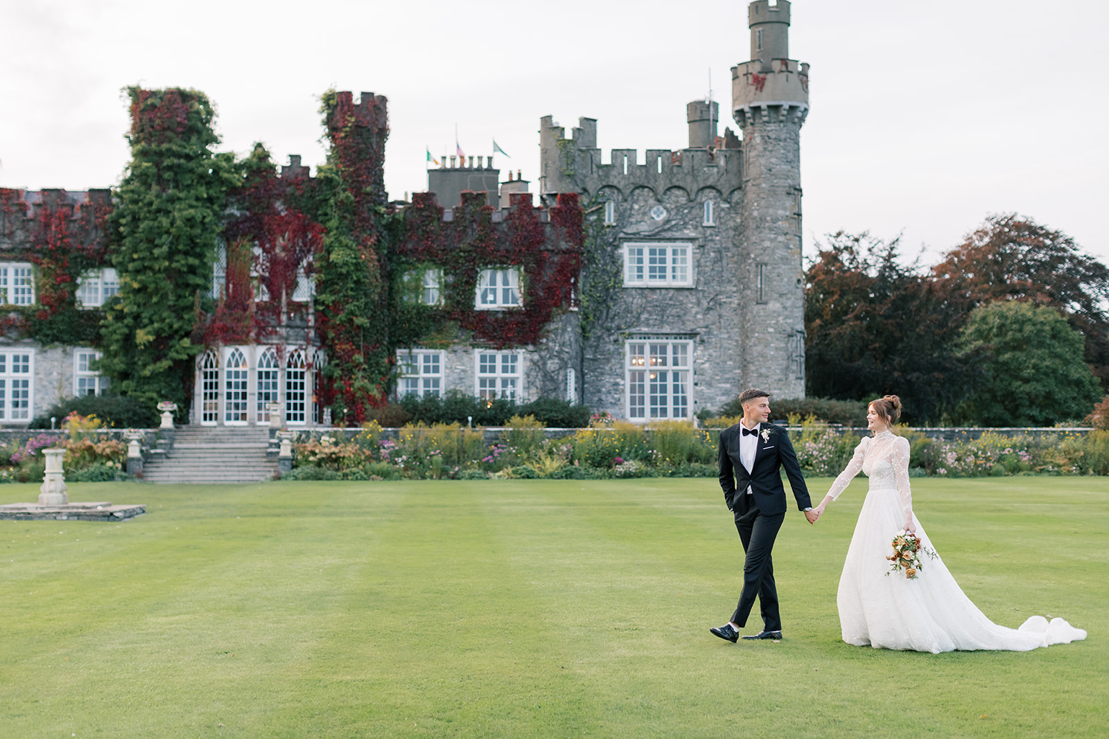 married couple walking with luttrellstown castle as backdrop