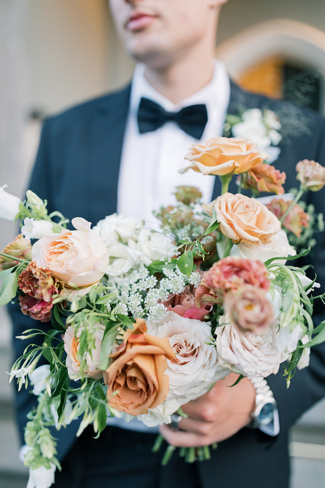 floral details held by groom at castle wedding venue