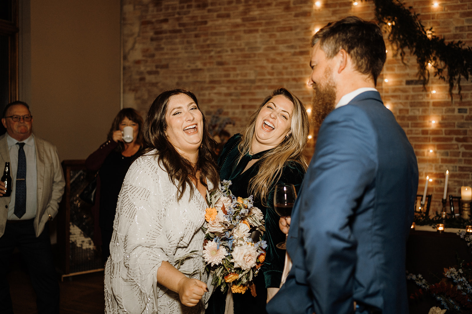 The bride laughing with guests at her wedding.