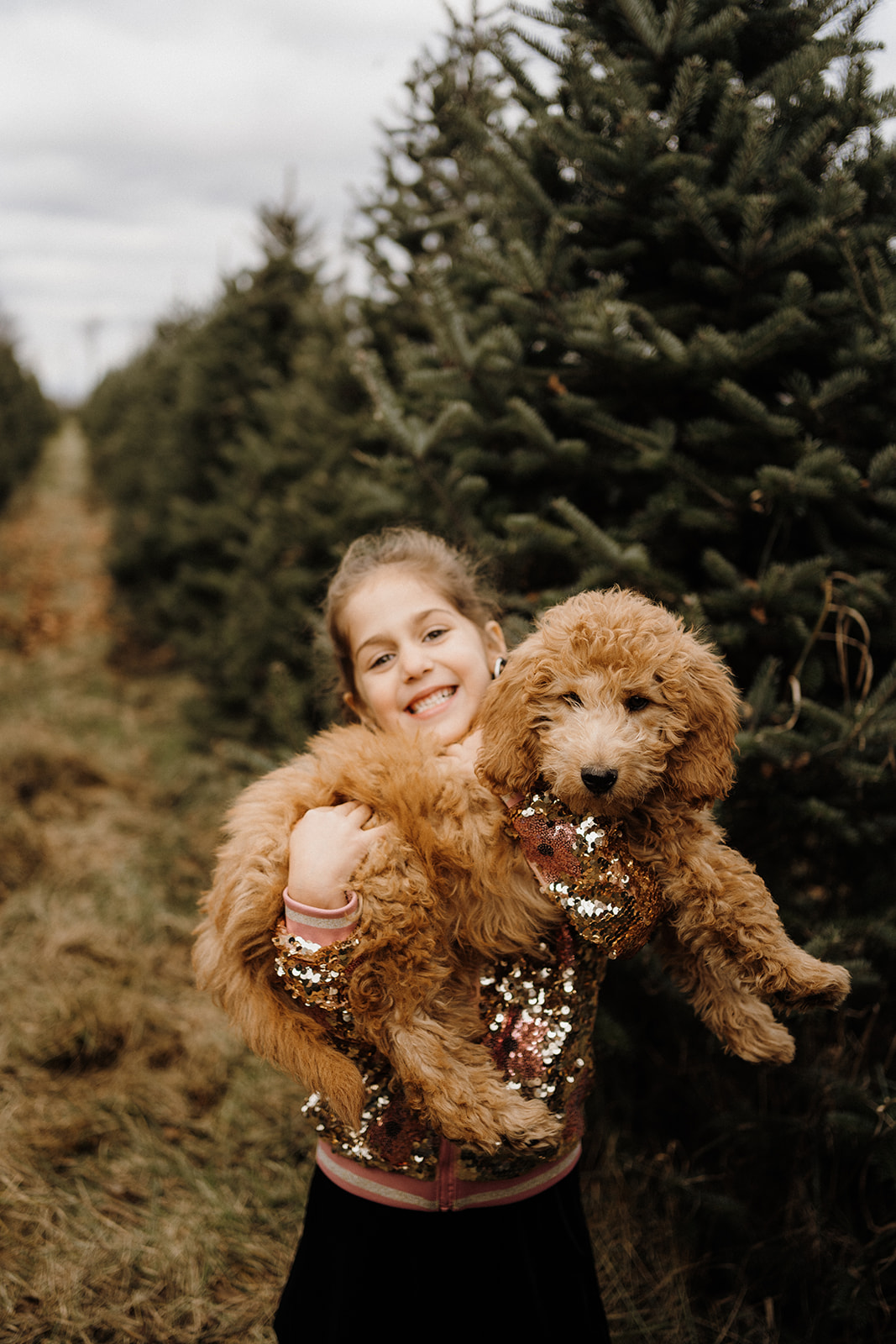 A child holding her dog outside.